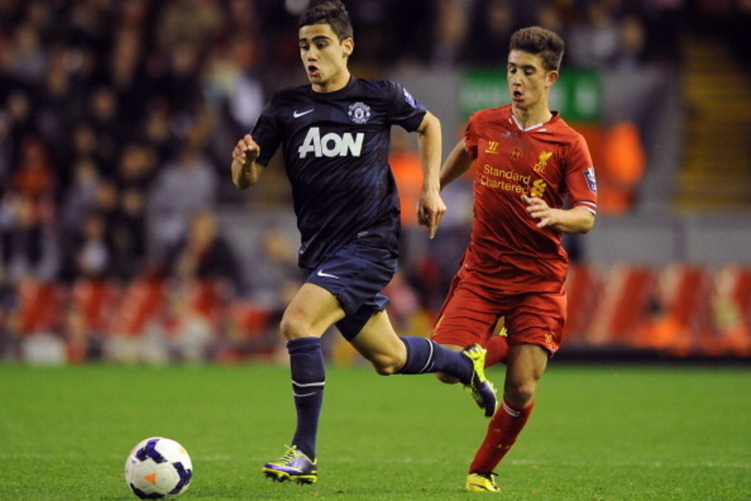 LIVERPOOL, ENGLAND - MAY 02: Andreas Pereira of Manchester United runs away from Cameron Brannagan of Liverpool during the Barclays U21 Premier League Semi Final match between Liverpool and Manchester United at Anfield on May 02, 2014 in Liverpool, Englan