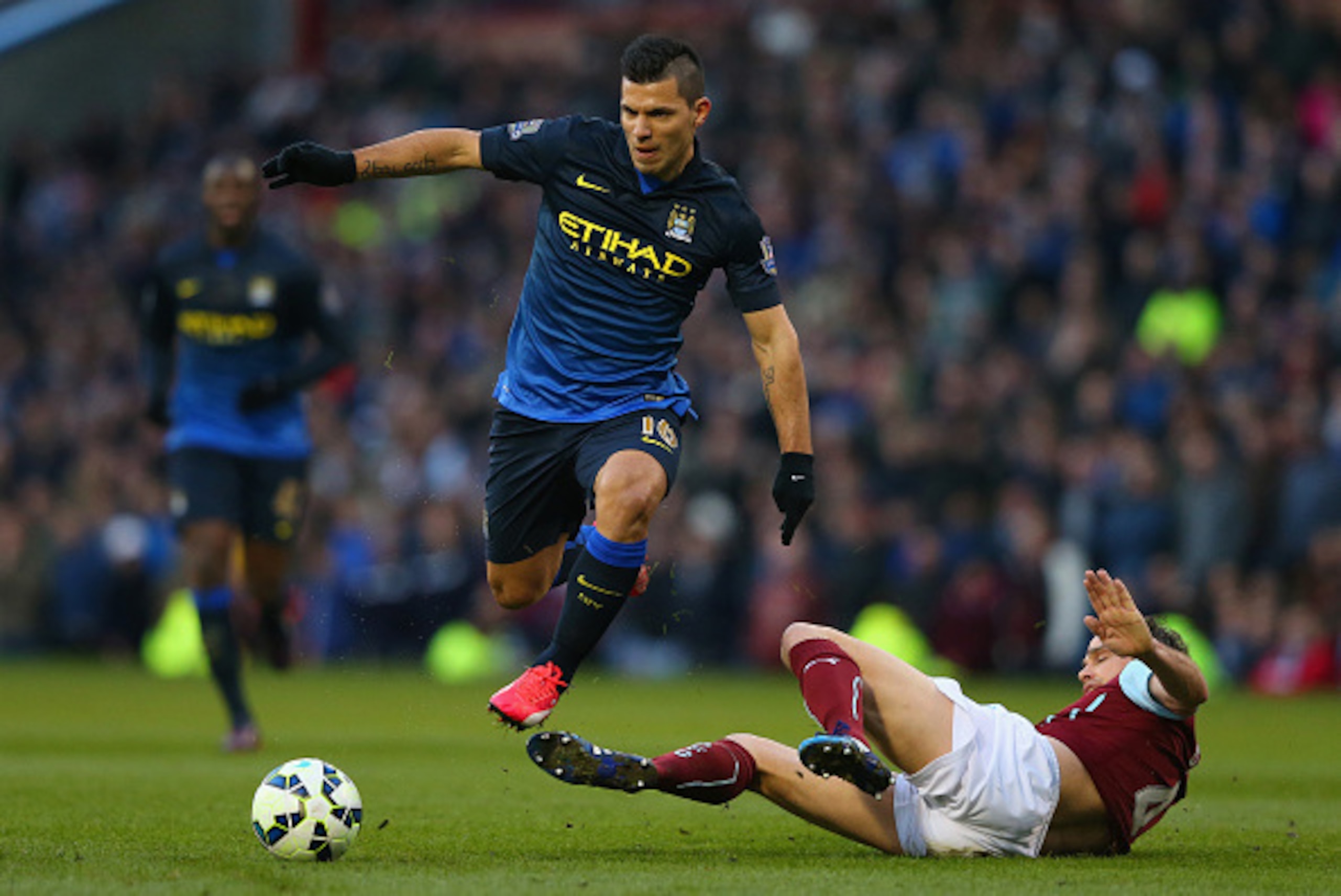 BURNLEY, ENGLAND - MARCH 14:  Sergio Aguero of Manchester City evades the challenge Michael Duff of Burnley during the Barclays Premier League match between Burnley and Manchester City at Turf Moor on March 14, 2015 in Burnley, England.  (Photo by Alex Li