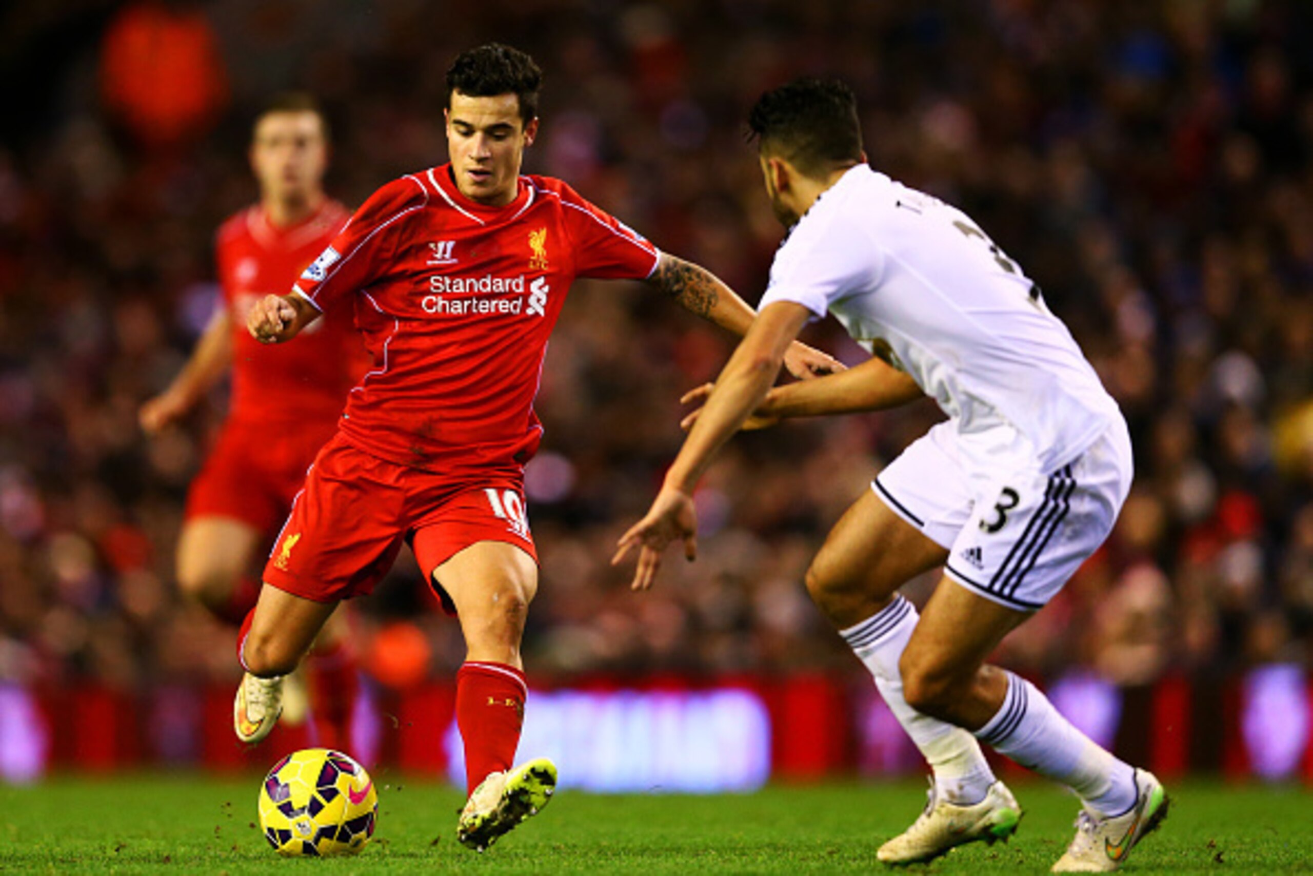 LIVERPOOL, ENGLAND - DECEMBER 29:  Philippe Coutinho of Liverpool shoots past Neil Taylor of Swansea City during the Barclays Premier League match between Liverpool and Swansea City at Anfield on December 29, 2014 in Liverpool, England.  (Photo by Clive B