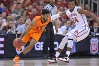 Mar 12, 2015; Kansas City, MO, USA; Oklahoma State Cowboys guard Jeff Newberry (22) dribbles the ball as Oklahoma Sooners guard Buddy Hield (24) defends during the first round at Sprint Center. Mandatory Credit: Denny Medley-USA TODAY Sports