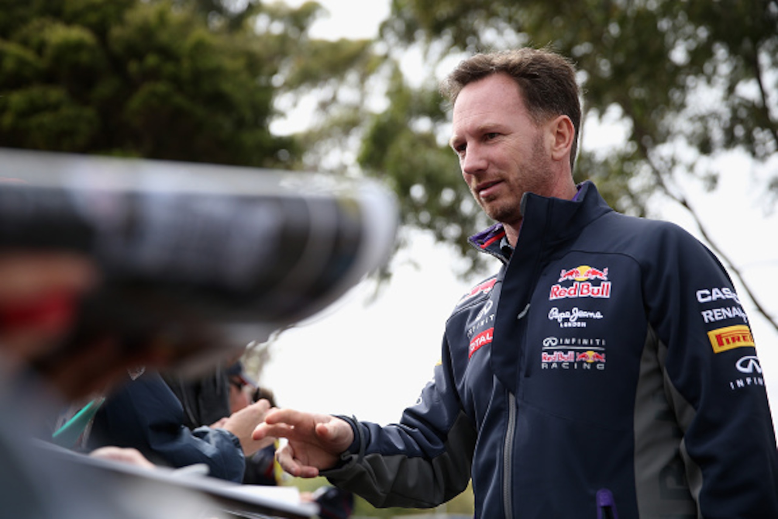 MELBOURNE, AUSTRALIA - MARCH 15:  Infiniti Red Bull Racing Team Principal Christian Horner signs autographs for fans as he arrives for the Australian Formula One Grand Prix at Albert Park on March 15, 2015 in Melbourne, Australia.  (Photo by Clive Mason/G