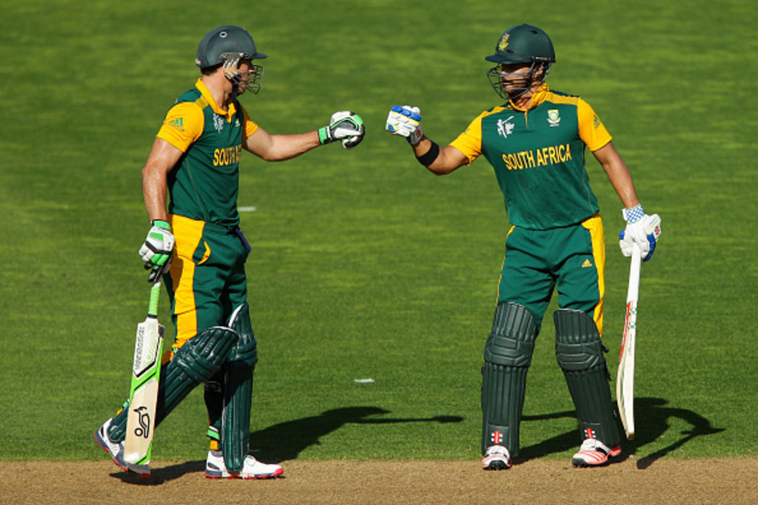 WELLINGTON, NEW ZEALAND - MARCH 12:  AB de Villiers (L) and JP Duminy of South Africa bump fists while batting during the 2015 ICC Cricket World Cup match between South Africa and the United Arab Emirates at Wellington Regional Stadium on March 12, 2015 i