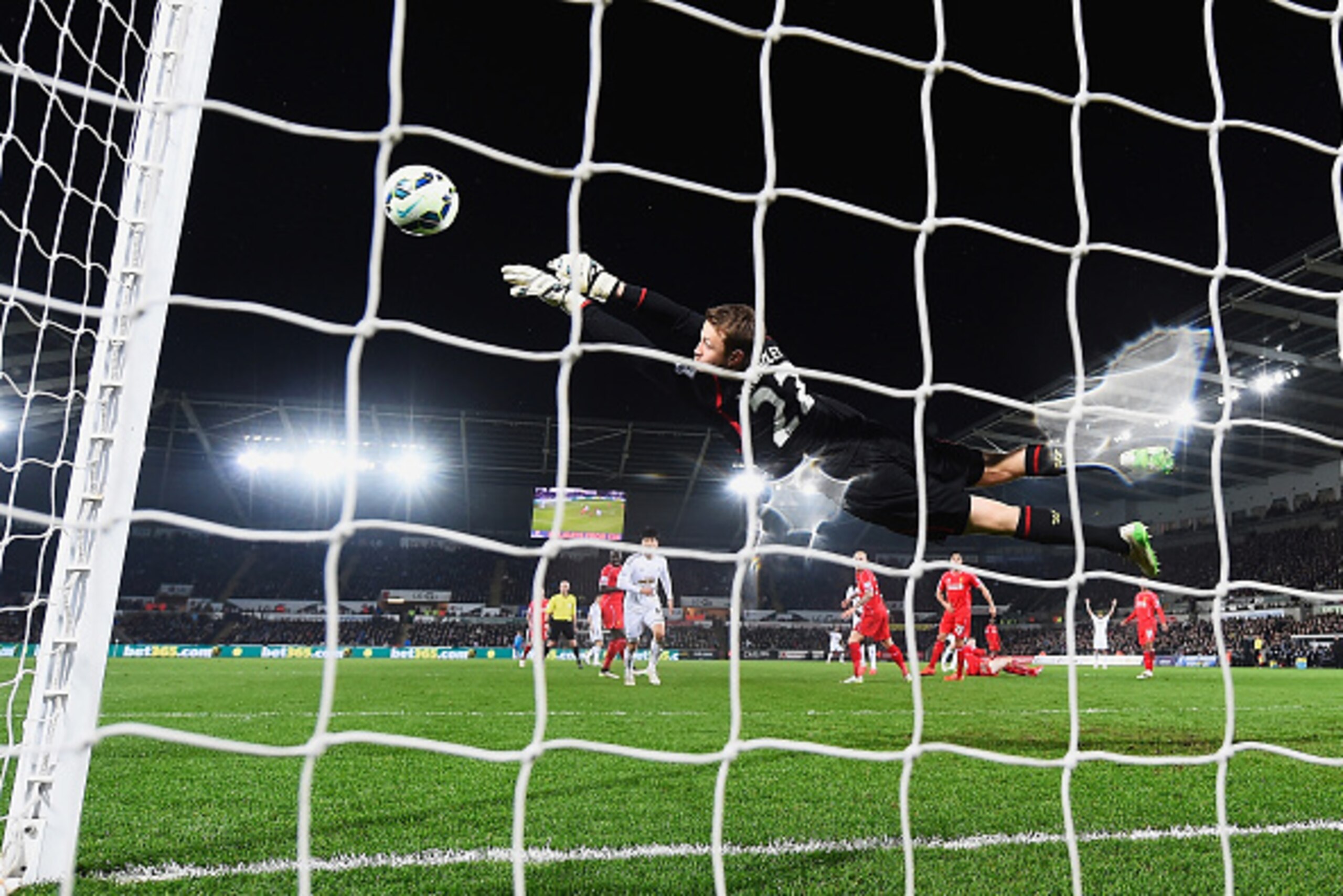 SWANSEA, WALES - MARCH 16: Simon Mignolet of Liverpool makes a save from Gylfi Sigurdsson of Swansea City during the Barclays Premier League match between Swansea City and Liverpool at Liberty Stadium on March 16, 2015 in Swansea, Wales. (Photo by Mike H SWANSEA, WALES - MARCH 16: Simon Mignolet of Liverpool makes a save from Gylfi Sigurdsson of Swansea City during the Barclays Premier League match between Swansea City and Liverpool at Liberty Stadium on March 16, 2015 in Swansea, Wales. (Photo by Mike H