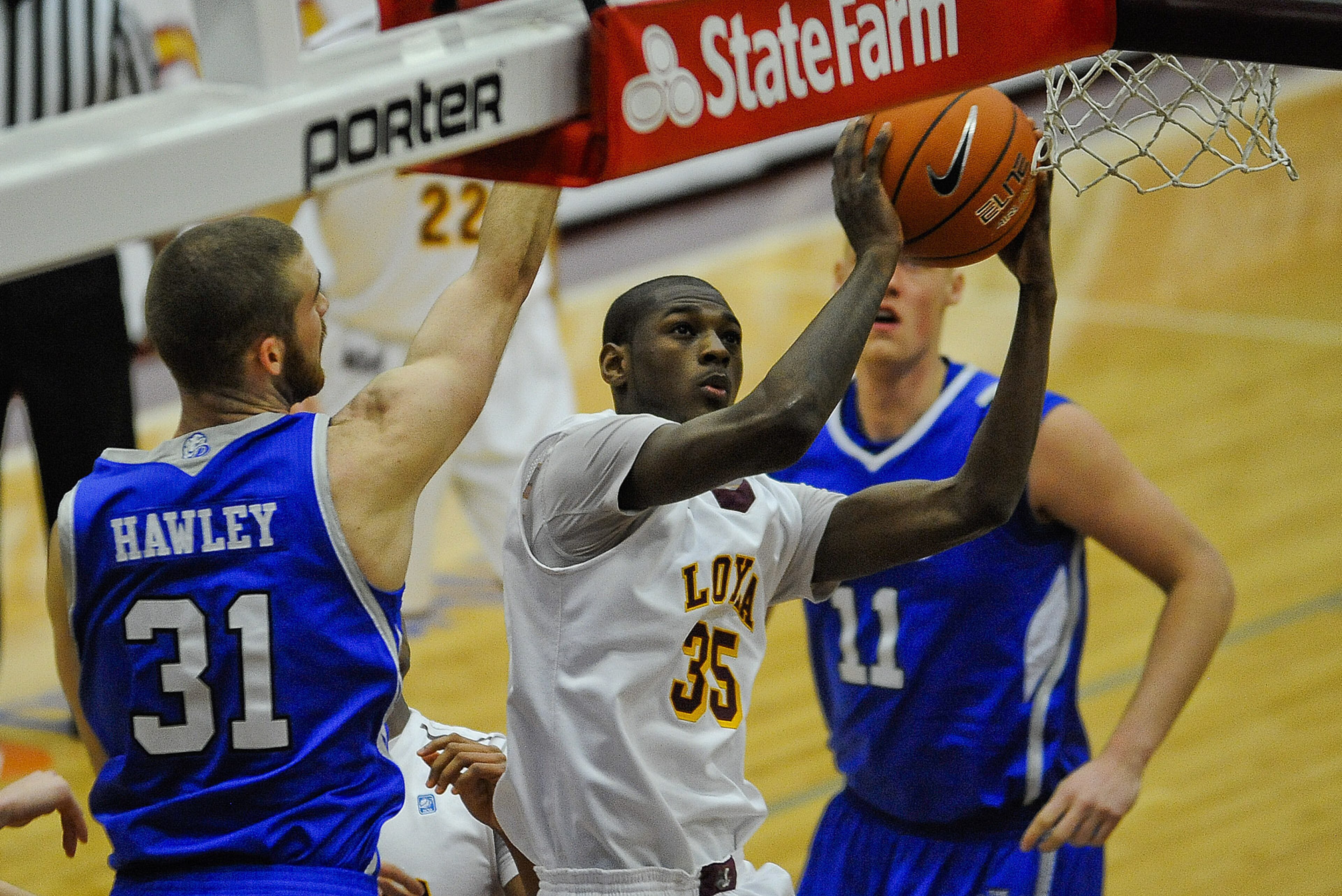 Jan 15, 2014; Chicago, IL, USA; Loyola (Il) Ramblers guard Milton Doyle (35) shoots against Drake Bulldogs guard/forward Aaron Hawley (31) and Drake Bulldogs center Jacob Enevold Jensen (11) during the first half of their game at Joseph J. Gentile Center.