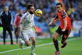 MADRID, SPAIN - JANUARY 31:  Daniel Carvajal of Real Madrid is tackled by Sergio Canales of  Real Sociedad Club De Futbol during the La Liga match between Real Madrid CF and Real Sociedad de Futbol at Estadio Santiago Bernabeu on January 31, 2015 in Madri
