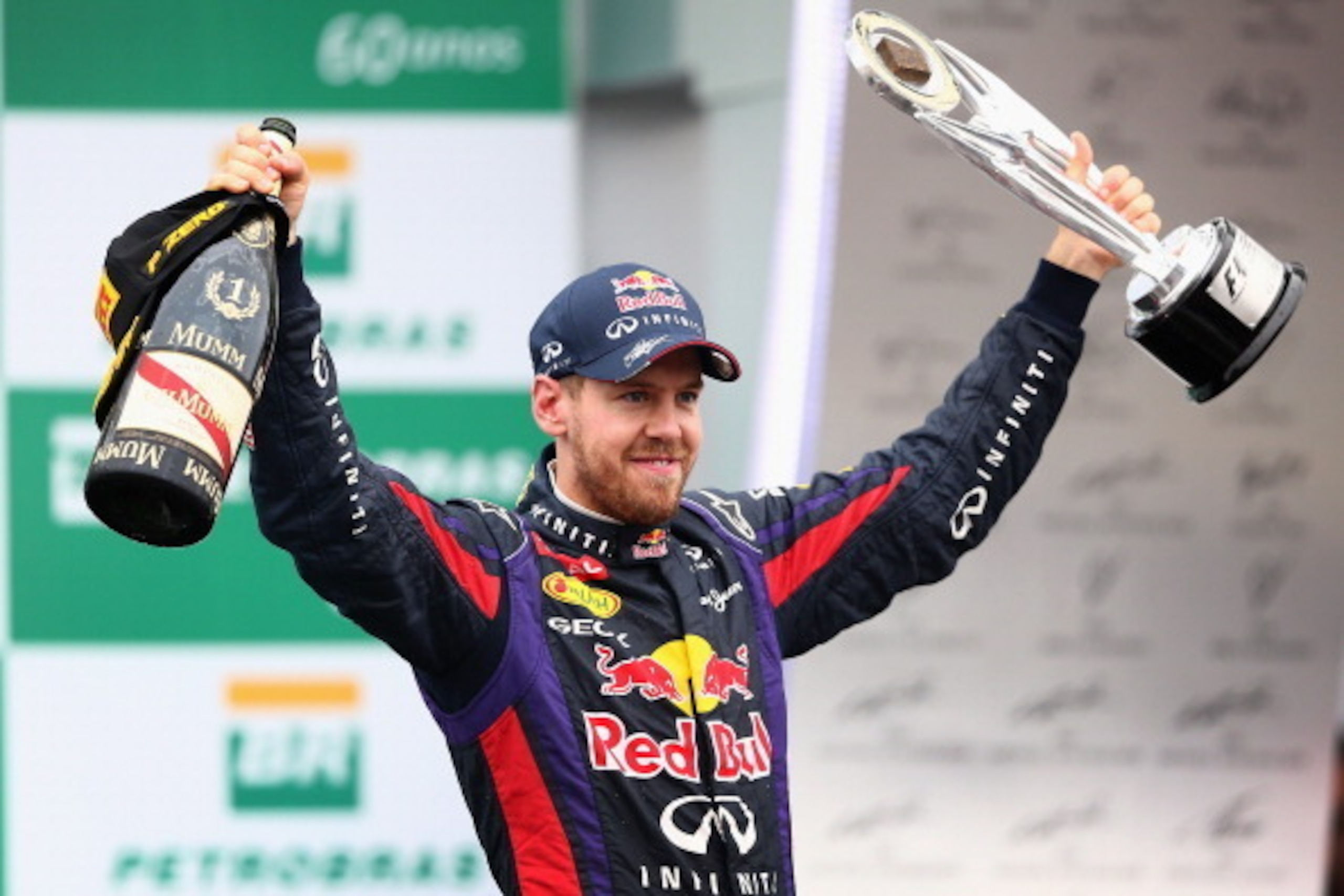 SAO PAULO, BRAZIL - NOVEMBER 24:  Sebastian Vettel of Germany and Infiniti Red Bull Racing celebrates on the podium after winning the Brazilian Formula One Grand Prix at Autodromo Jose Carlos Pace on November 24, 2013 in Sao Paulo, Brazil.  (Photo by Cliv