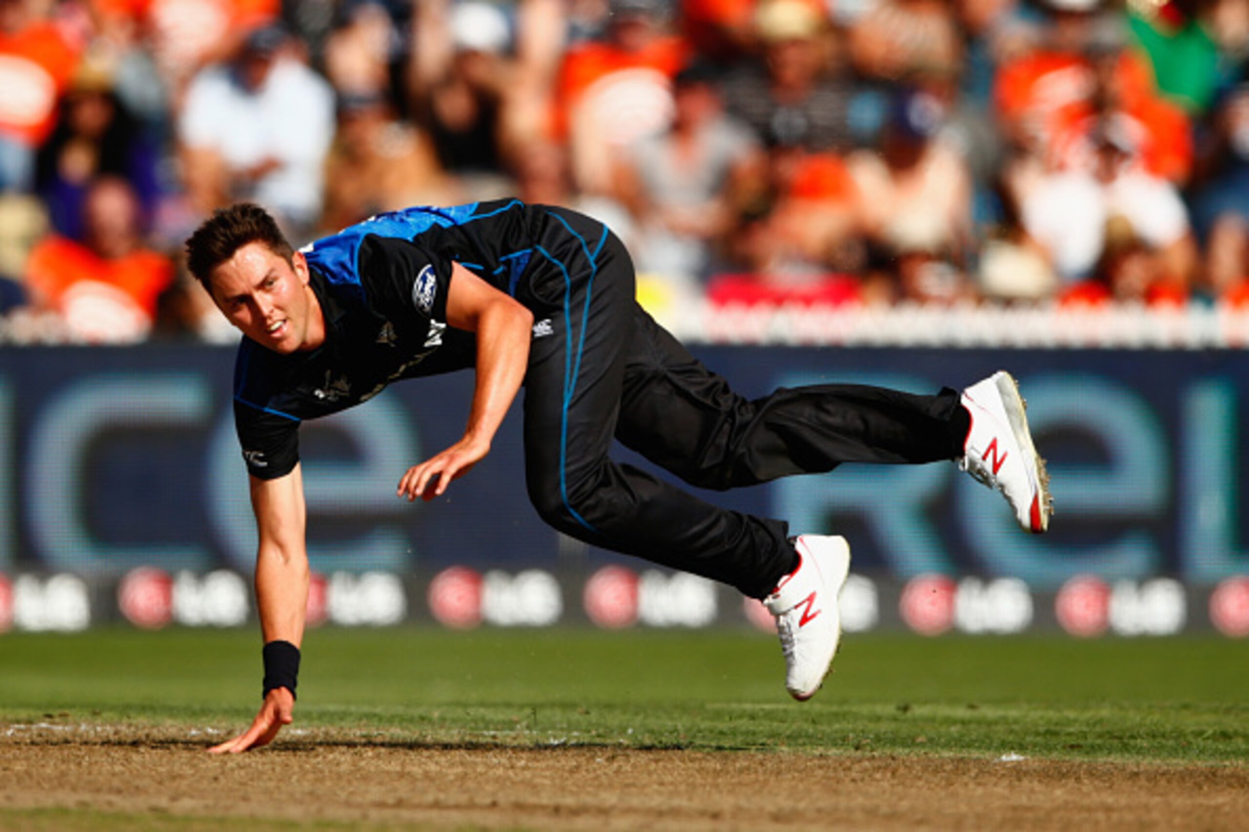 HAMILTON, NEW ZEALAND - MARCH 13: Trent Boult of New Zealand falls over bowling during the 2015 ICC Cricket World Cup match between Bangladesh and New Zealand at Seddon Park on March 13, 2015 in Hamilton, New Zealand.  (Photo by Phil Walter/Getty Images)