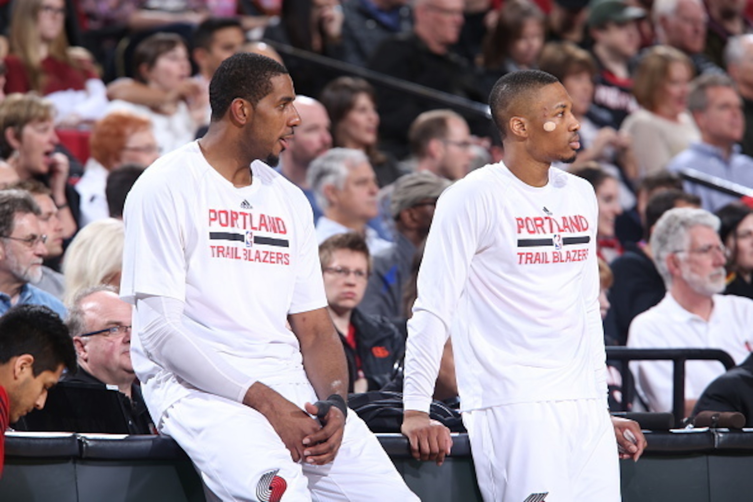 PORTLAND, OR - MARCH 13: LaMarcus Aldridge #12 and Damian Lillard #0 of the Portland Trail Blazers wait to check in during a game against the Detroit Pistons on March 13, 2015 at the Moda Center Arena in Portland, Oregon. NOTE TO USER: User expressly ackn