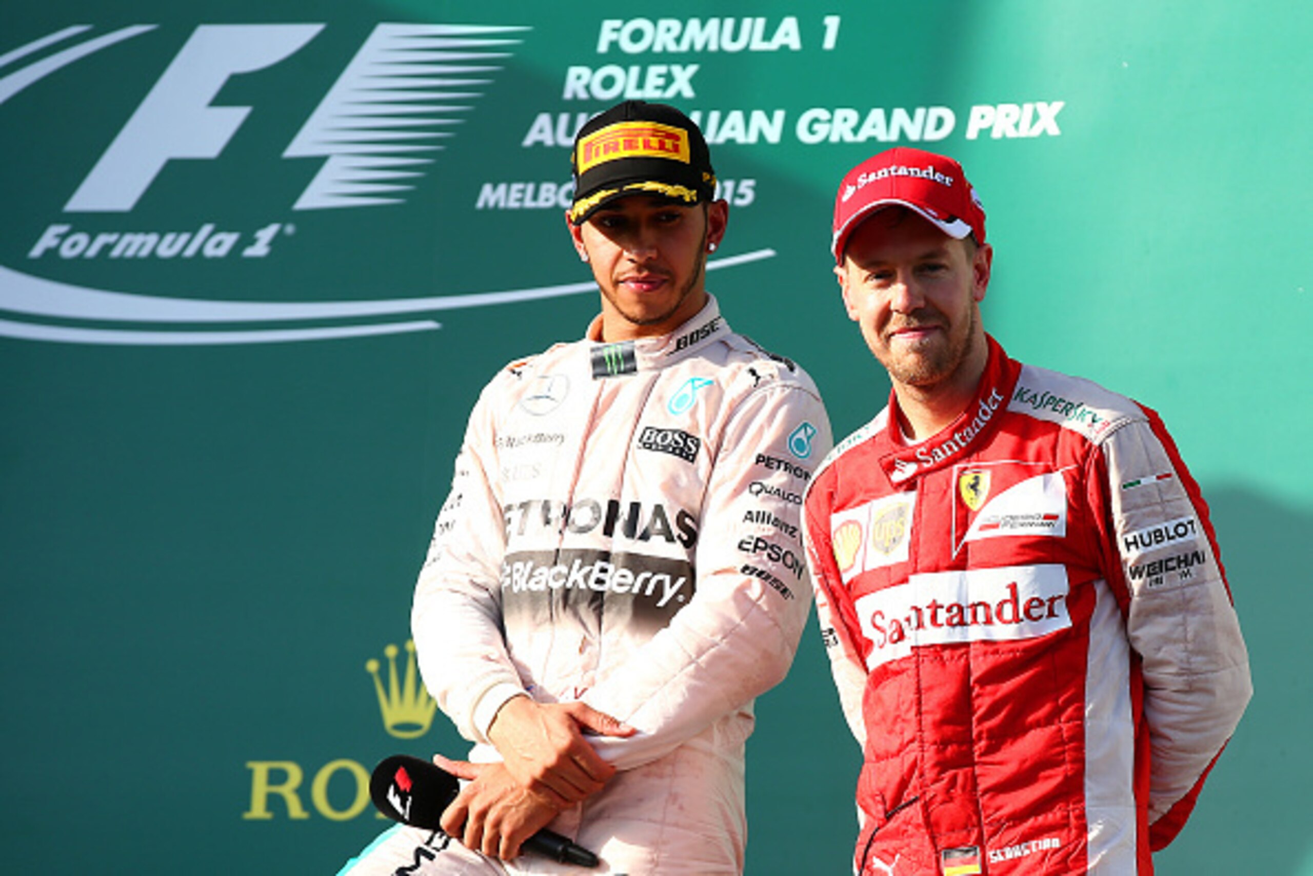 MELBOURNE, AUSTRALIA - MARCH 15:  Lewis Hamilton of Great Britain and Mercedes GP celebrates on the podium with Sebastian Vettel of Germany and Ferrari after winning the Australian Formula One Grand Prix at Albert Park on March 15, 2015 in Melbourne, Aust