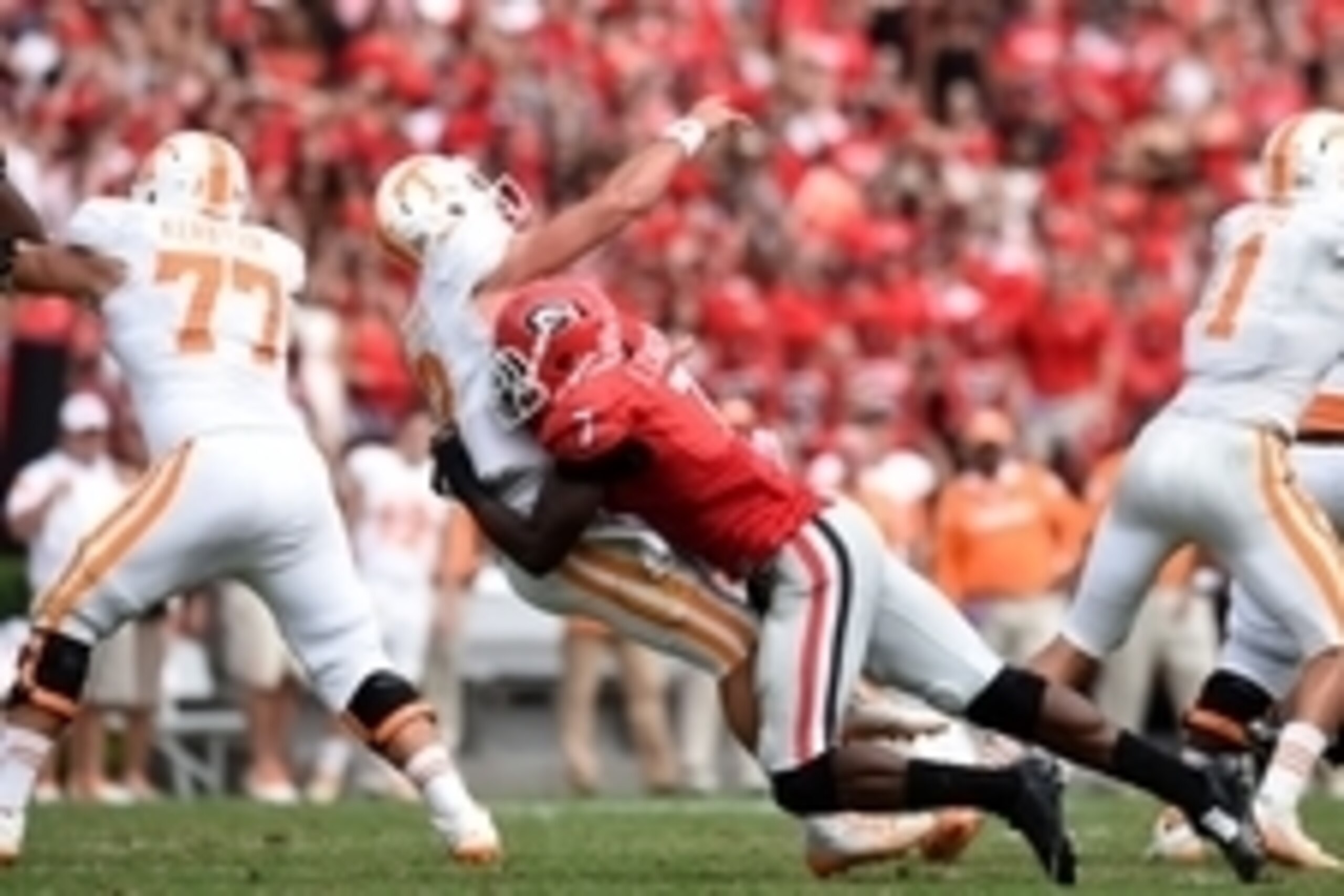 Sep 27, 2014; Athens, GA, USA; Georgia Bulldogs linebacker Lorenzo Carter (7) hits Tennessee Volunteers quarterback Nathan Peterman (12) as he releases the ball during the second half at Sanford Stadium. Georgia defeated Tennessee 35-32. Mandatory Credit: