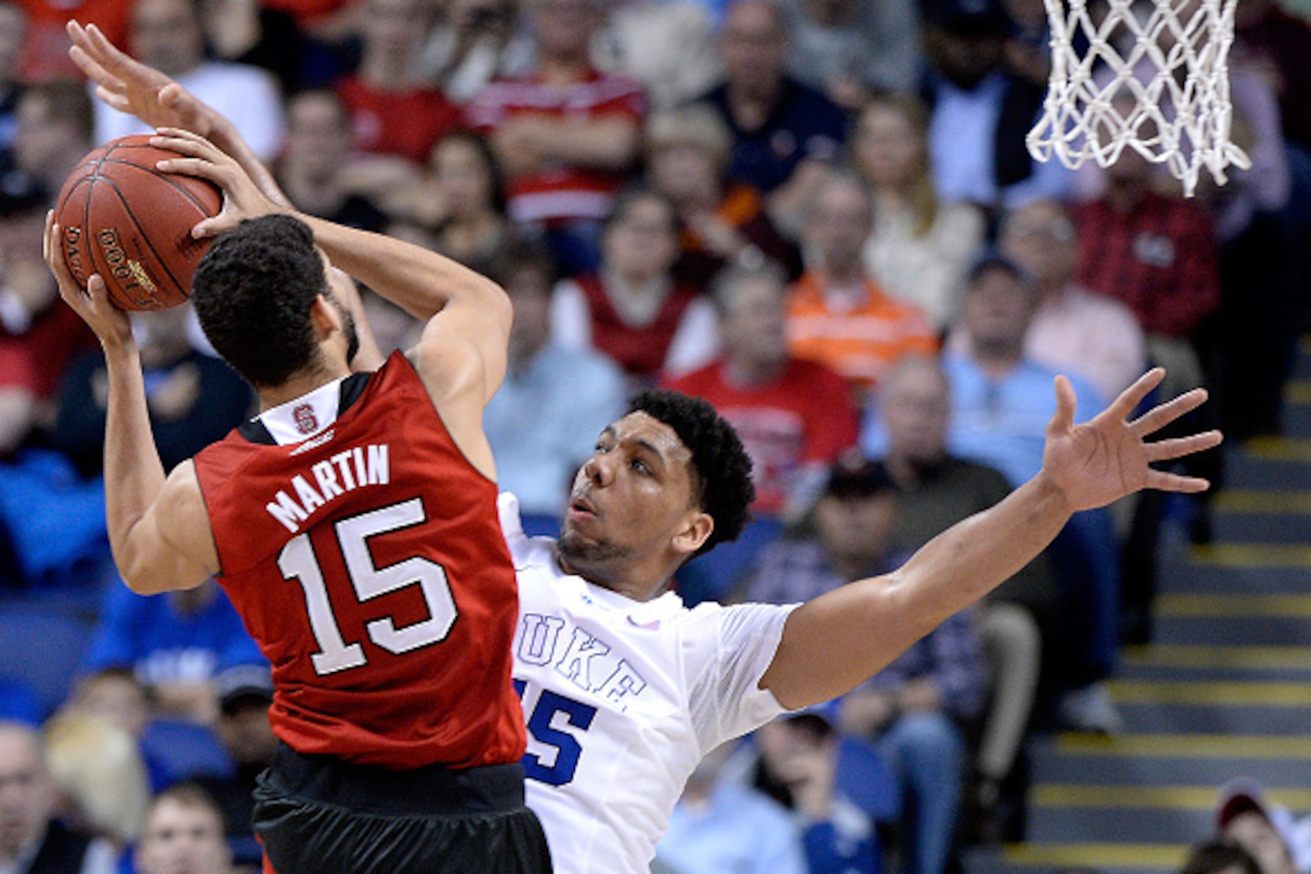 GREENSBORO, NC - MARCH 12:  Jahlil Okafor #15 of the Duke Blue Devils challenges a shot by Cody Martin #15 of the North Carolina State Wolfpack during the quarterfinals of the ACC Basketball Tournament at Greensboro Coliseum on March 12, 2015 in Greensbor