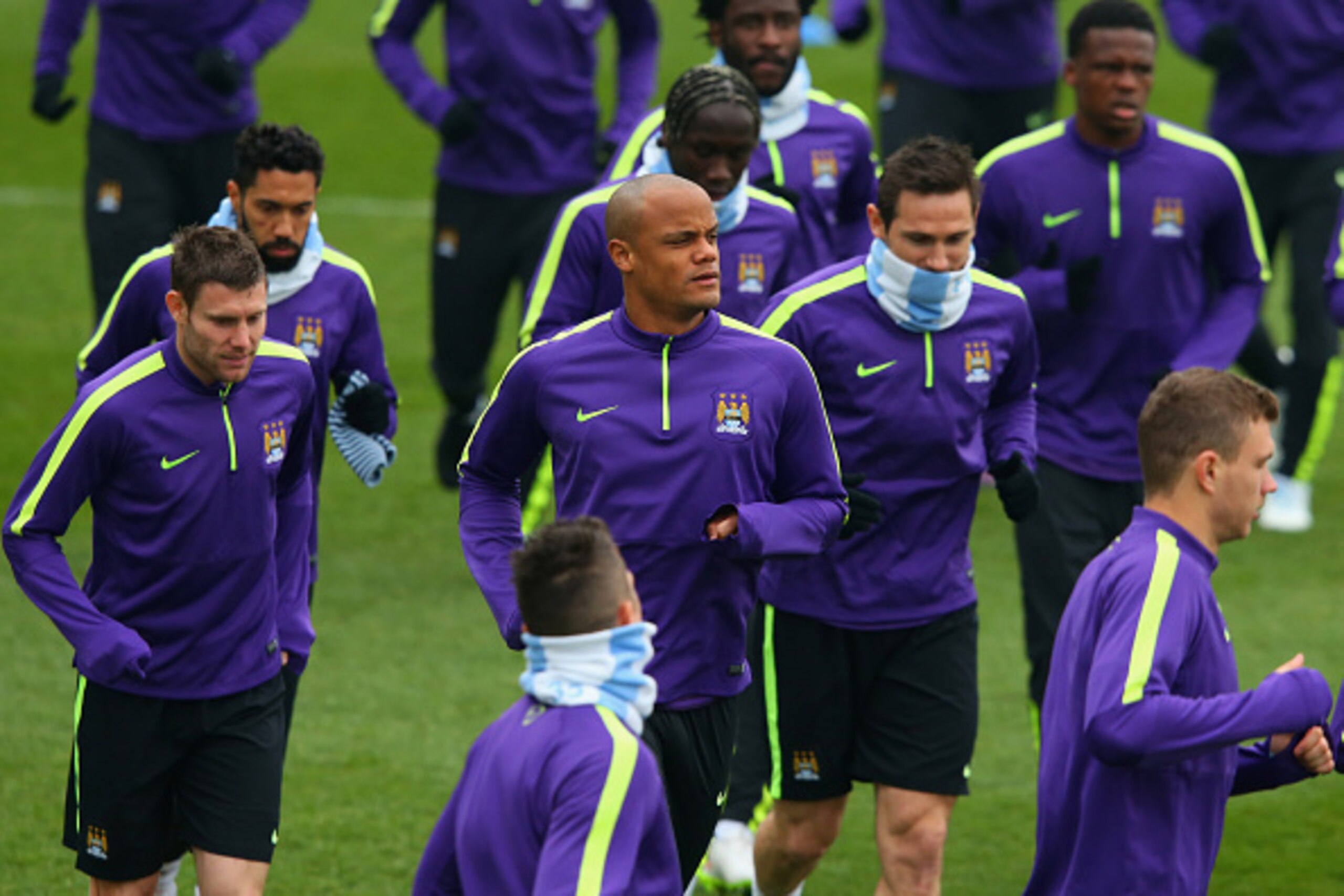 MANCHESTER, ENGLAND - MARCH 17:  Captain Vincent Kompany (C) warms up alongside team mates during a Manchester City training session ahead of the UEFA Champions League round of 16 second leg match against Barcelona at Etihad Campus on March 17, 2015 in Ma
