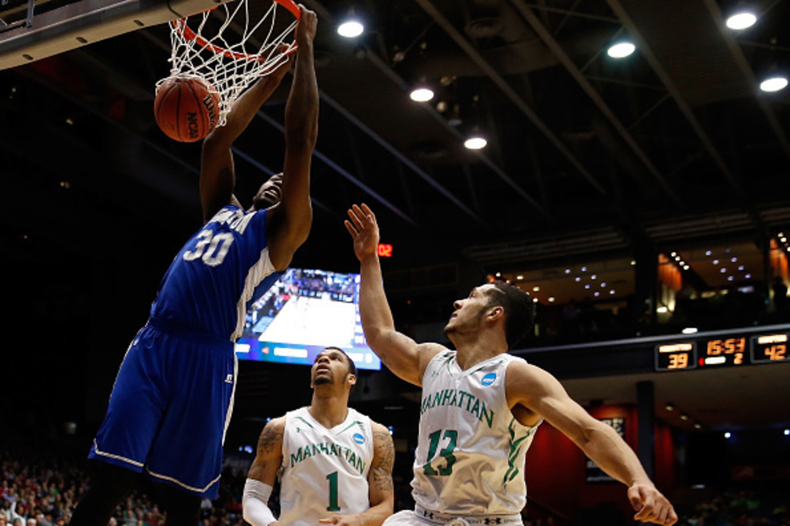 DAYTON, OH - MARCH 17:  Jervon Pressley #30 of the Hampton Pirates dunks as Emmy Andujar #13 of the Manhattan Jaspers defends during the first round of the 2015 NCAA Men's Basketball Tournament at UD Arena on March 17, 2015 in Dayton, Ohio.  (Photo by Gre