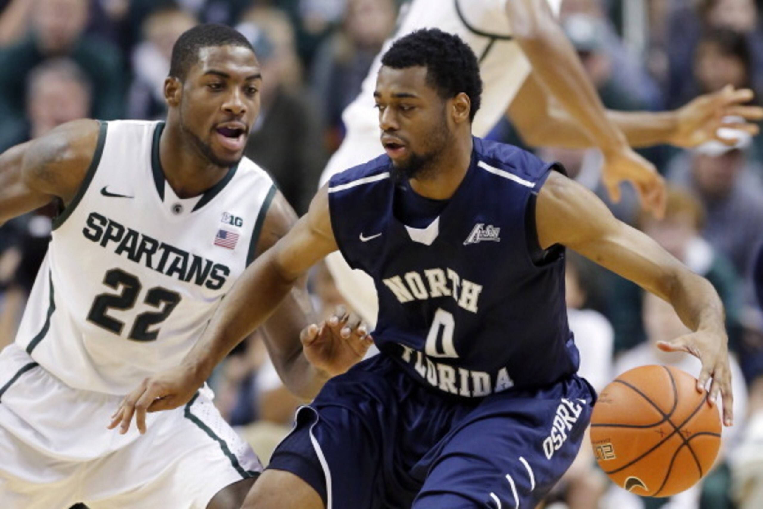 EAST LANSING, MI - DECEMBER 17:  Branden Dawson #22 of the Michigan State Spartans puts the pressure on Jalen Nesbitt #0 of the North Florida Ospreys during the first half of a game at Breslin Center on December 17, 2013, in East Lansing, Michigan. (Photo