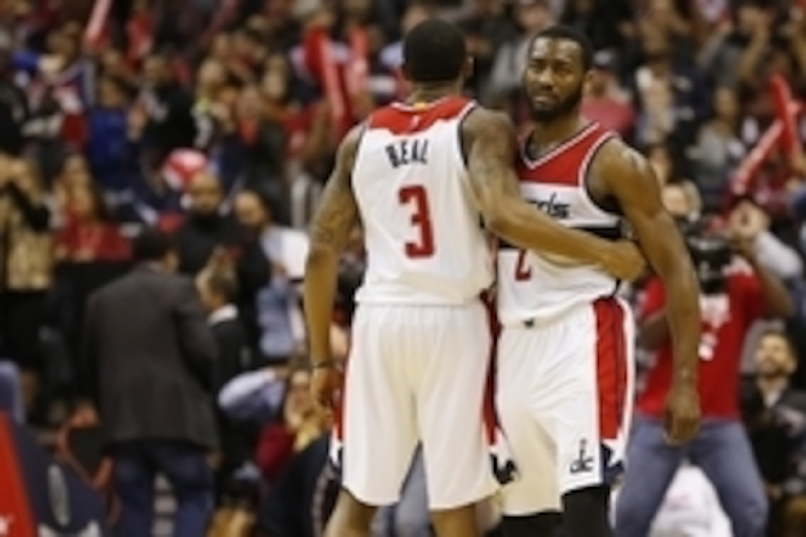Dec 23, 2014; Washington, DC, USA; Washington Wizards guard Bradley Beal (3) hugs Wizards guard John Wall (2) against the Chicago Bulls in the fourth quarter at Verizon Center. The Bulls won 99-91. Mandatory Credit: Geoff Burke-USA TODAY Sports
