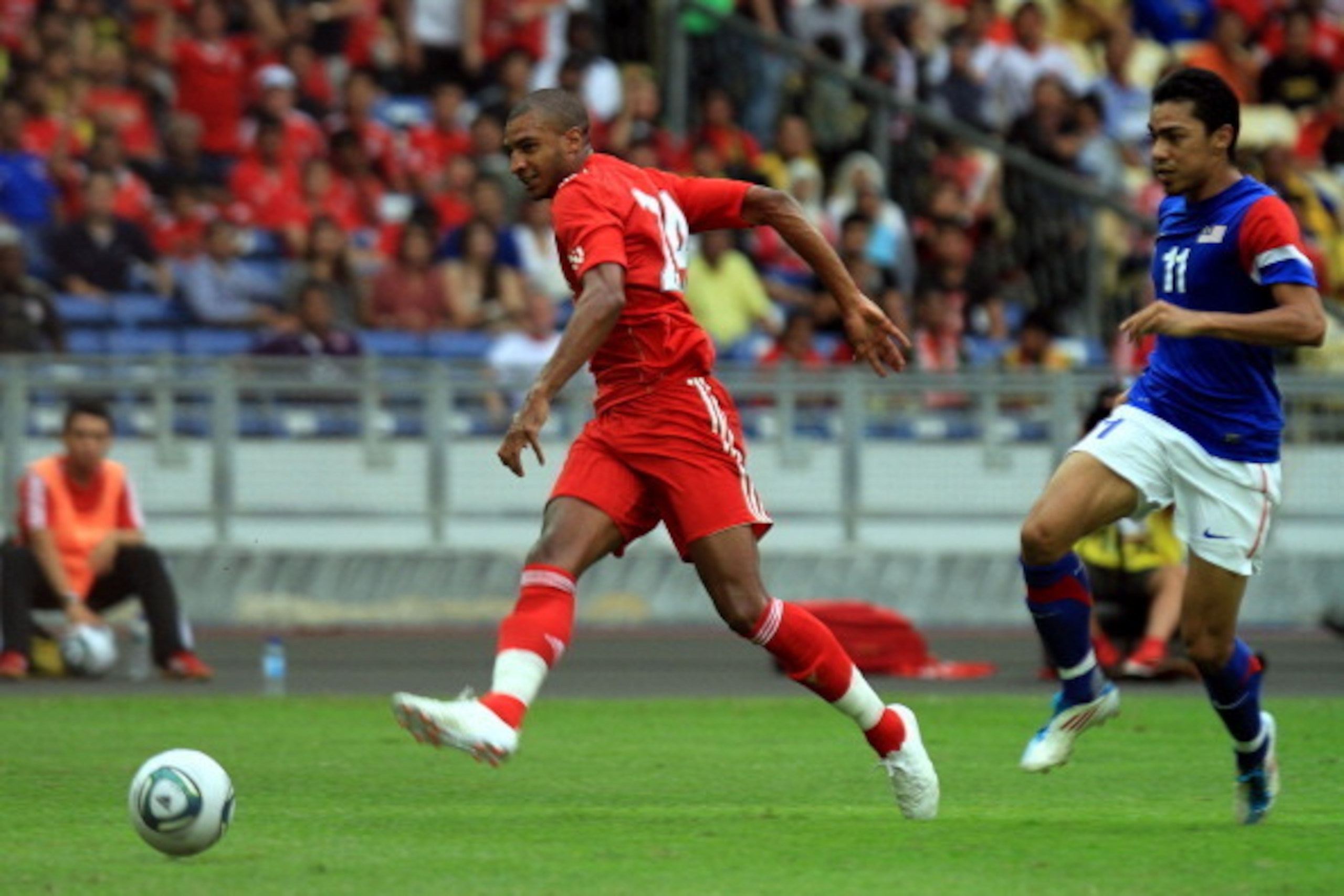 KUALA LUMPUR, MALAYSIA - JULY 16: David Ngog of Liverpool taps to score while Mohd Azmi of Malaysia looks on during the pre-season friendly match between Malaysia and Liverpool at the Bukit Jalil National Stadium on July 16, 2011 in Kuala Lumpur, Malaysia
