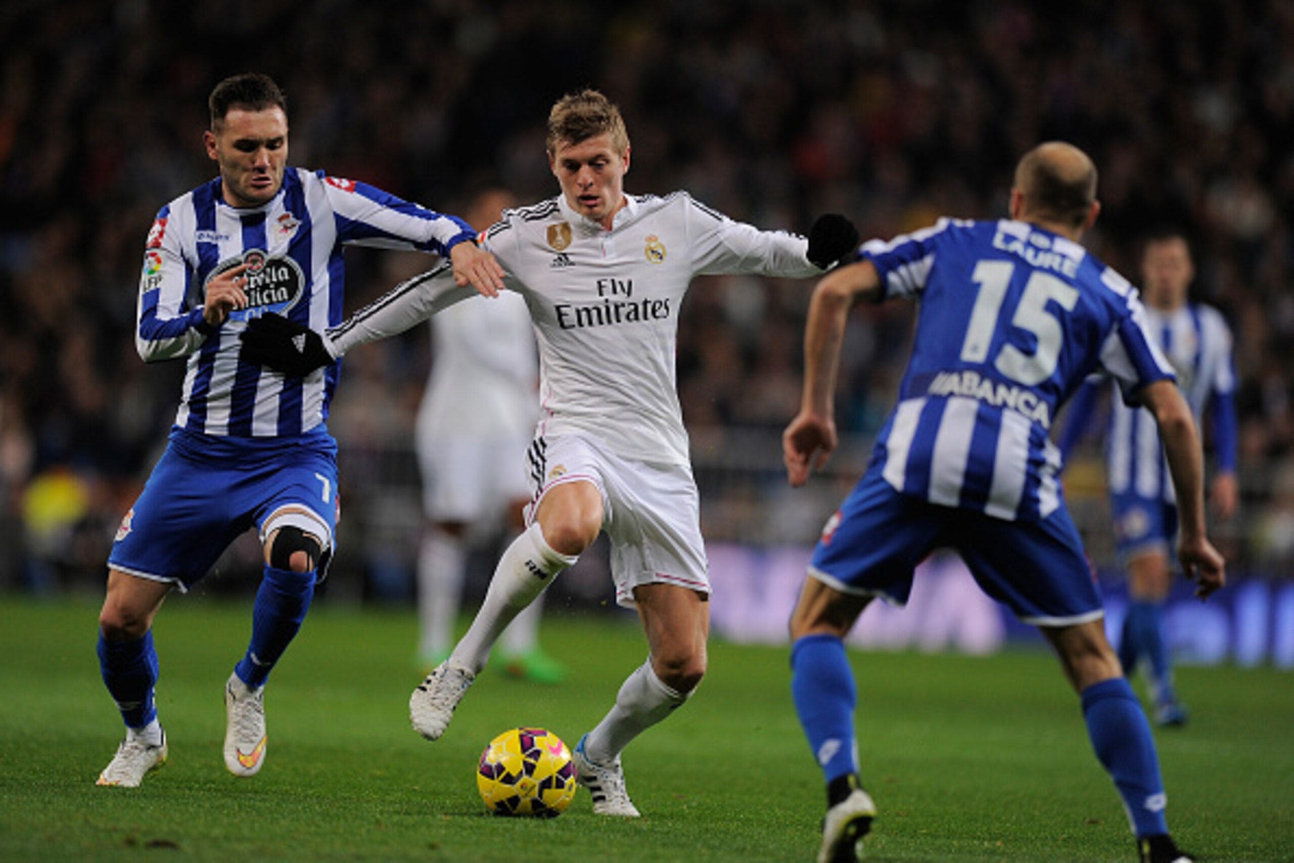 MADRID, SPAIN - FEBRUARY 15:  Toni Kroos of Real Madrid is tackled by Lucas Perez of  RC Deportivo La Coruna during the La Liga match between Real Madrid CF and RC Deportivo La Coruna at Estadio Santiago Bernabeu on February 15, 2015 in Madrid, Spain.  (P