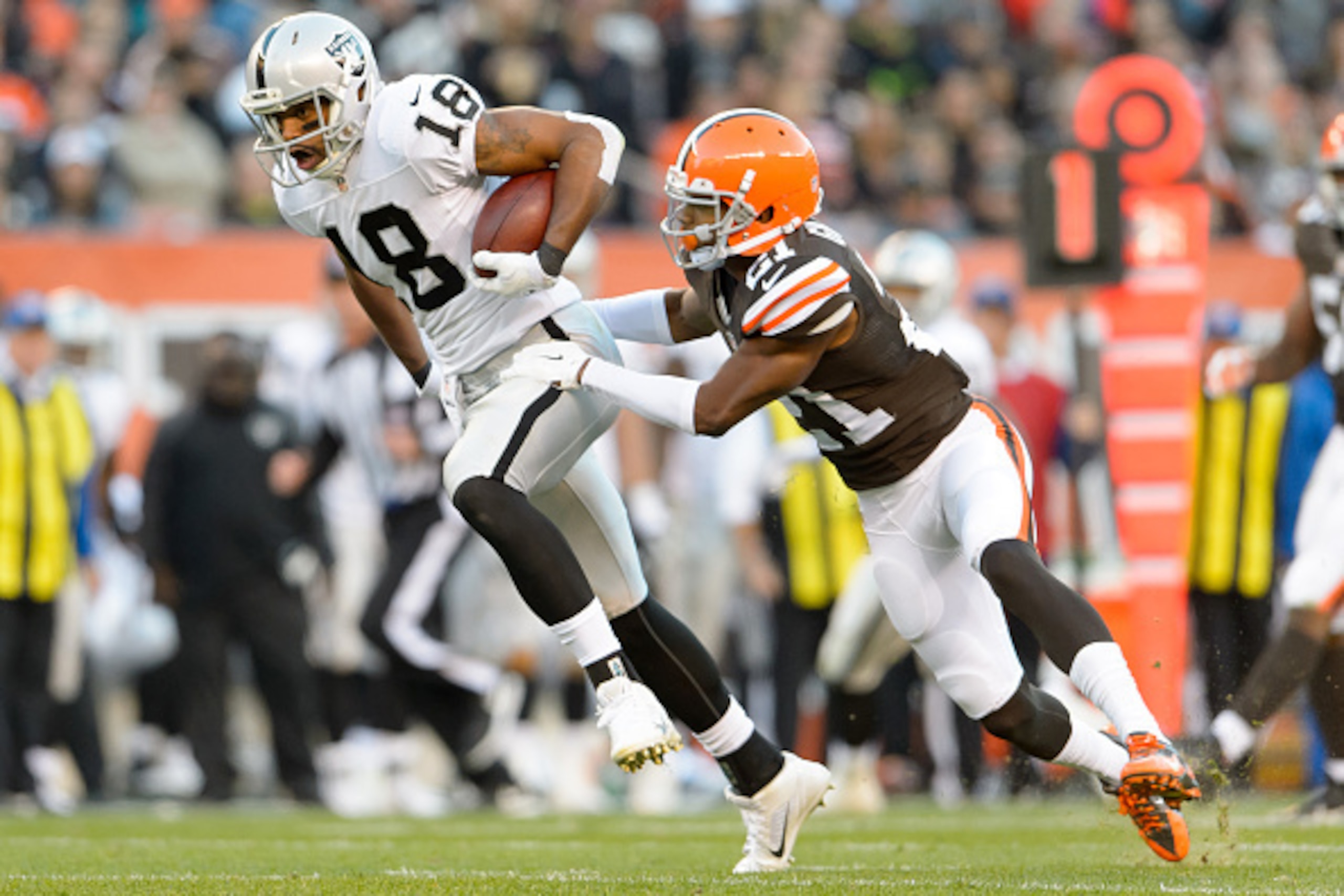 CLEVELAND, OH - OCTOBER 26: Wide receiver Andre Holmes #18 of the Oakland Raiders makes a catch while under pressure from cornerback Justin Gilbert #21 of the Cleveland Browns during the first half at FirstEnergy Stadium in Cleveland, Ohio. (Photo by Jaso