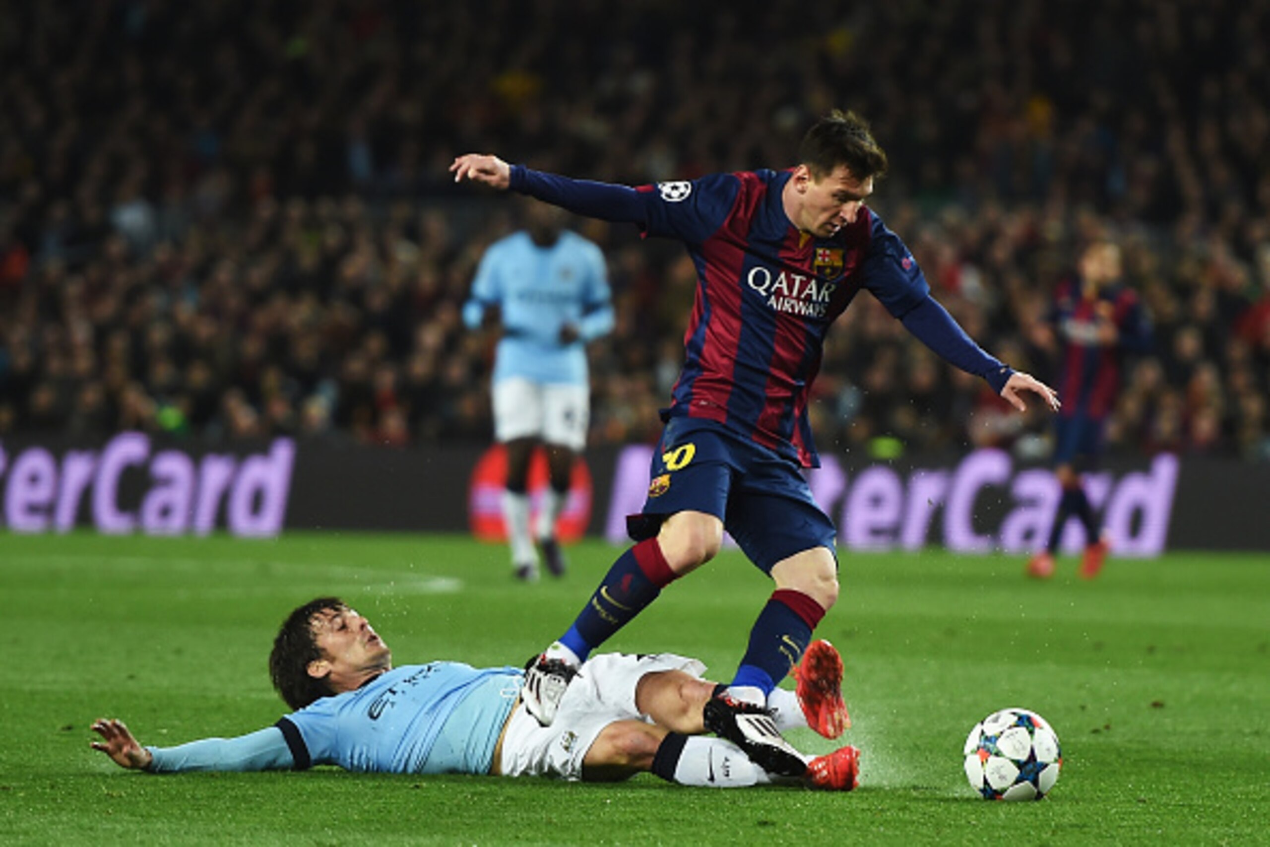 BARCELONA, SPAIN - MARCH 18:  David Silva of Manchester City tackles Lionel Messi of Barcelona during the UEFA Champions League Round of 16 second leg match between Barcelona and Manchester City at Camp Nou on March 18, 2015 in Barcelona, Spain.  (Photo b