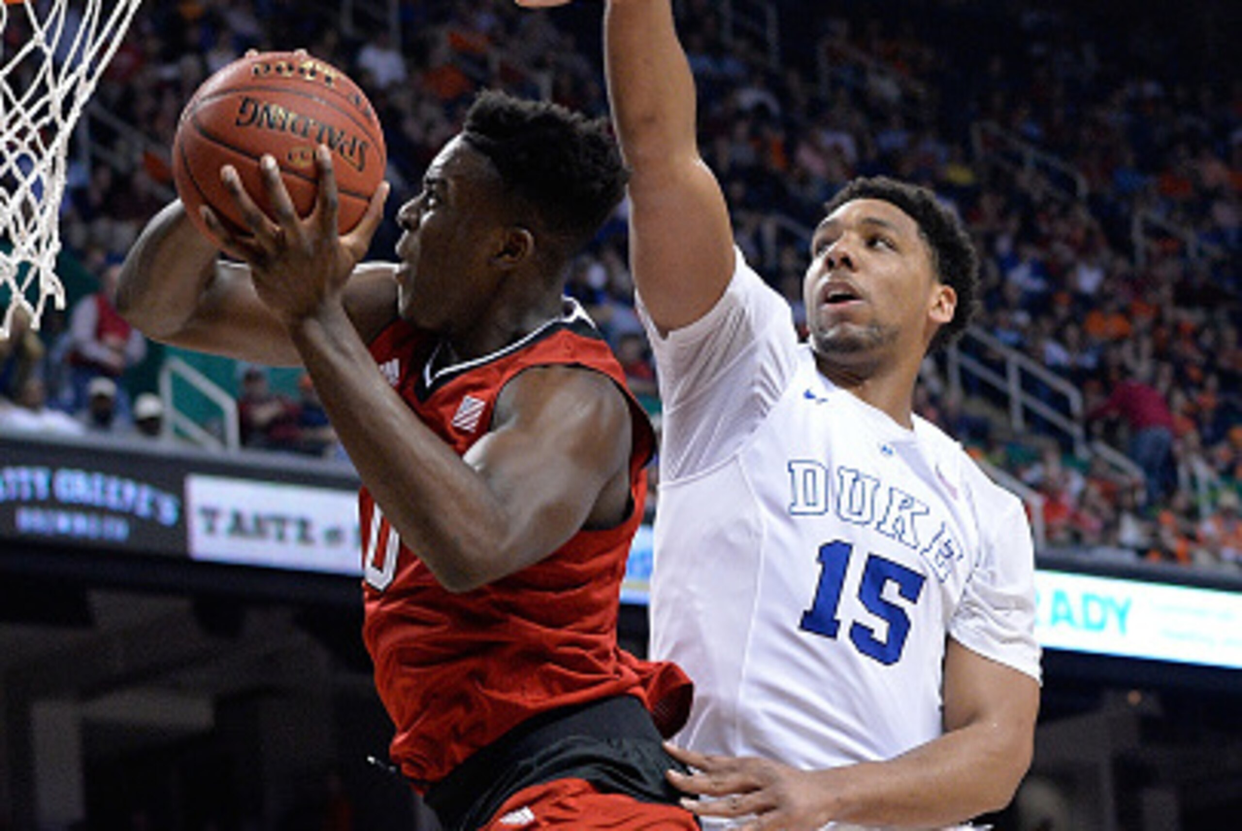 GREENSBORO, NC - MARCH 12:  Jahlil Okafor #15 of the Duke Blue Devils defends Abdul-Malik Abu #0 of the North Carolina State Wolfpack during the quarterfinals of the ACC Basketball Tournament at Greensboro Coliseum on March 12, 2015 in Greensboro, North C