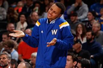 DENVER, CO - MARCH 13:  Stephen Curry #30 of the Golden State Warriors supports his teammates from the bench against the Denver Nuggets at Pepsi Center on March 13, 2015 in Denver, Colorado. NOTE TO USER: User expressly acknowledges and agrees that, by do