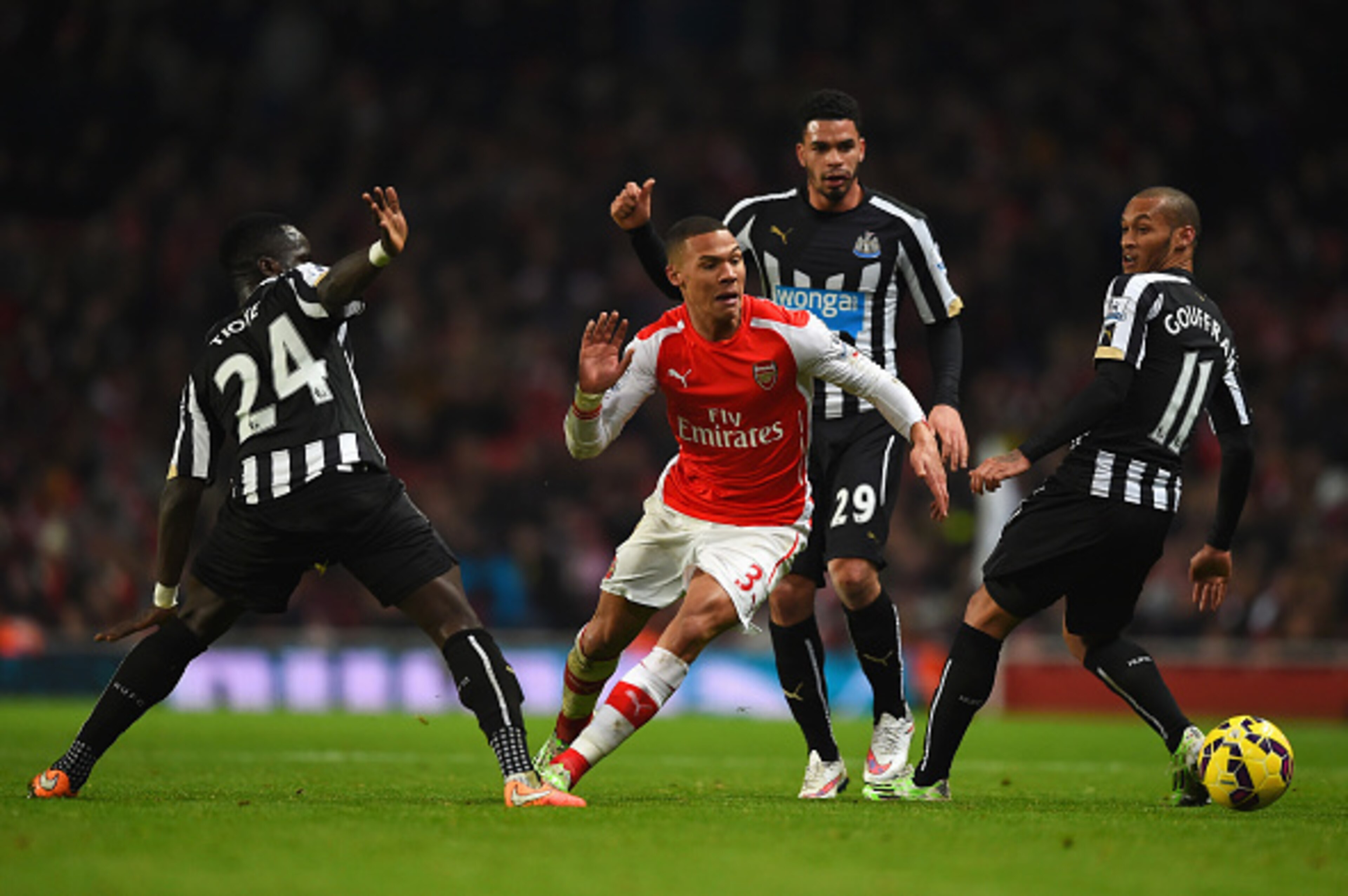 LONDON, ENGLAND - DECEMBER 13: Kieran Gibbs of Arsenal goes past Cheik Ismael Tiote (L), Emmanuel Riviere and Yoan Gouffran (R) of Newcastle United during the Barclays Premier League match between Arsenal and Newcastle United at Emirates Stadium on Decemb
