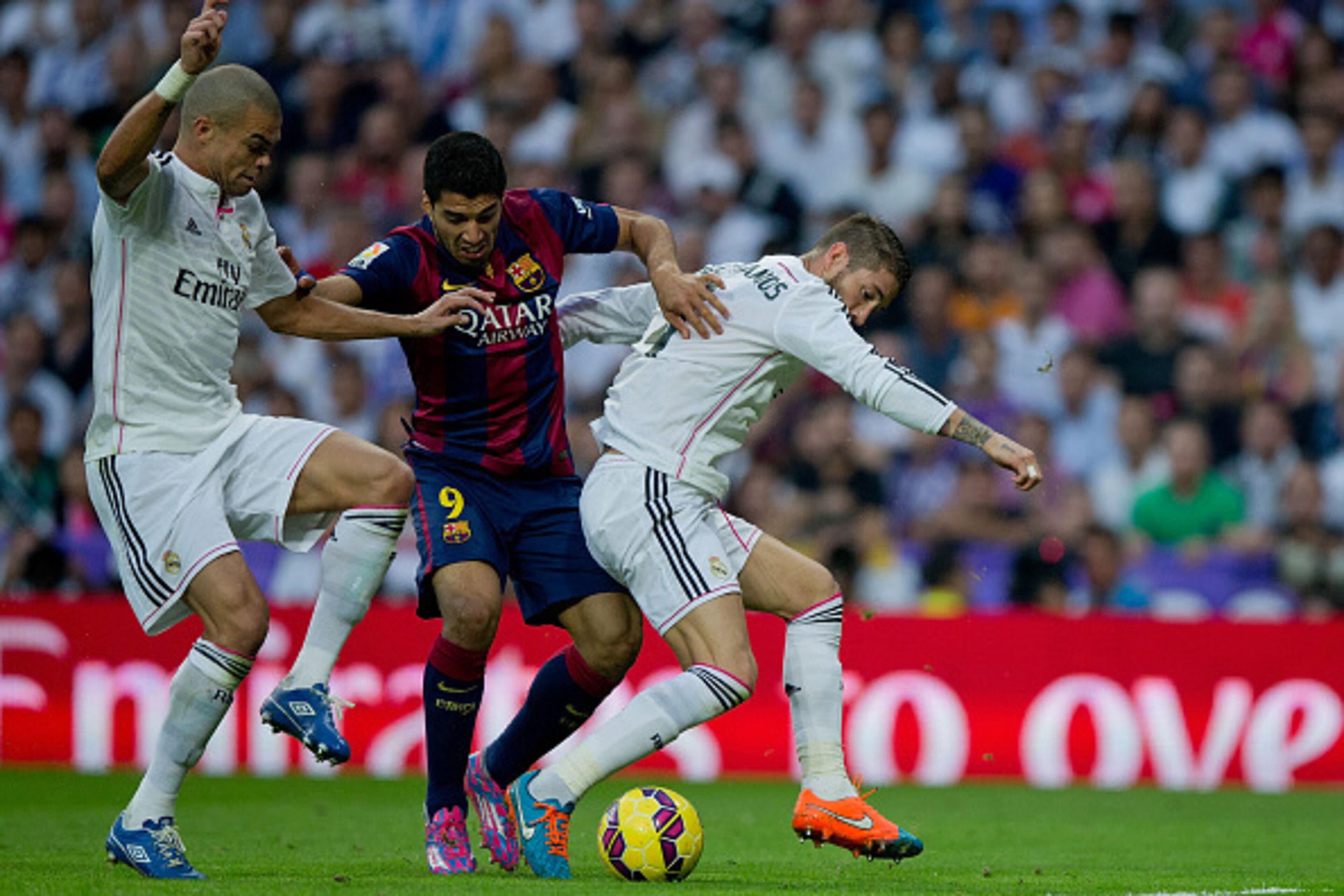 MADRID, SPAIN - OCTOBER 25: Luis Suarez (2ndL) of FC Barcelona competes for the ball with Pepe (L) of Real Madrid CF and his teammate Sergio Ramos (R) during the La Liga match between Real Madrid CF and FC Barcelona at Estadio Santiago Bernabeu on October