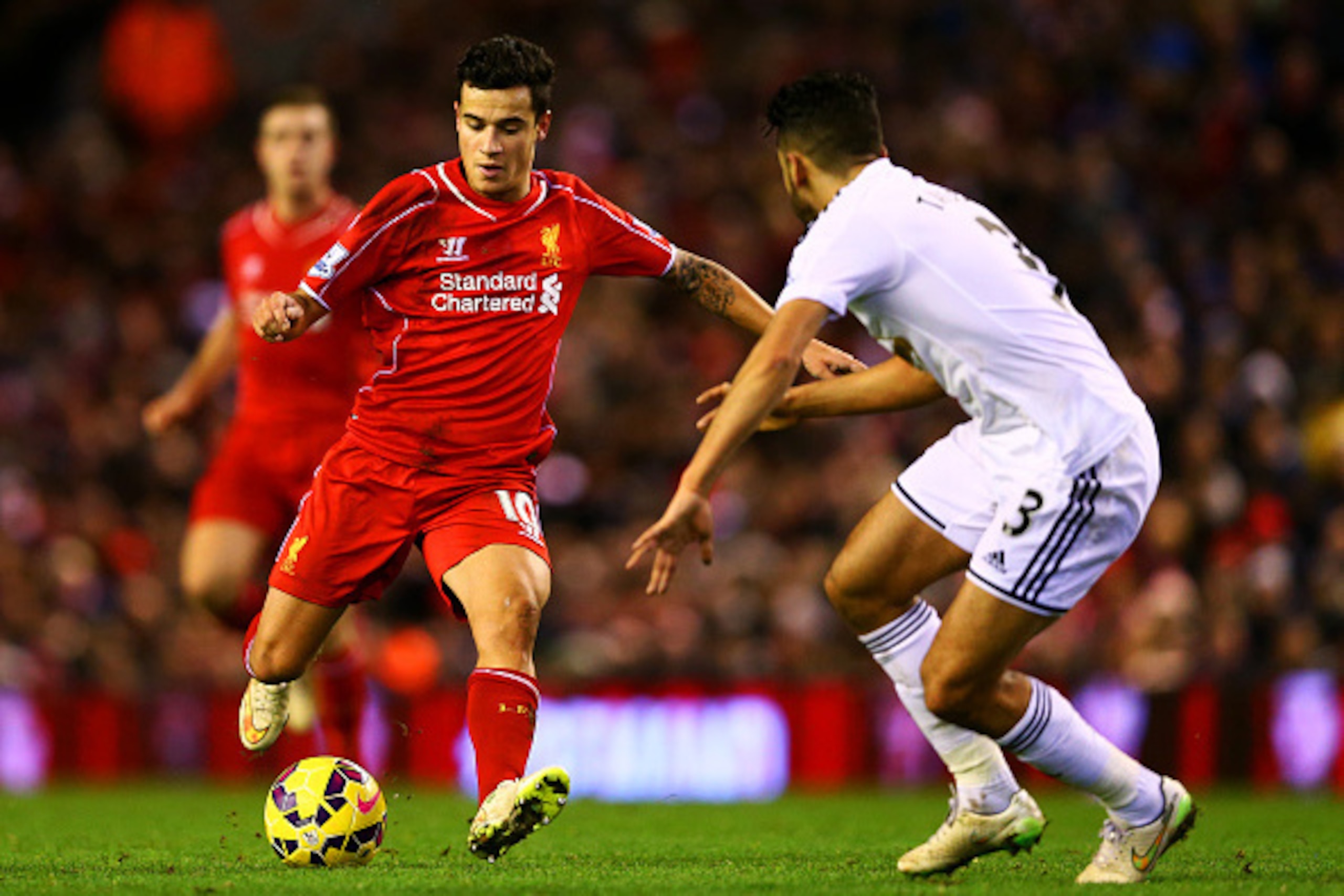 LIVERPOOL, ENGLAND - DECEMBER 29:  Philippe Coutinho of Liverpool shoots past Neil Taylor of Swansea City during the Barclays Premier League match between Liverpool and Swansea City at Anfield on December 29, 2014 in Liverpool, England.  (Photo by Clive B