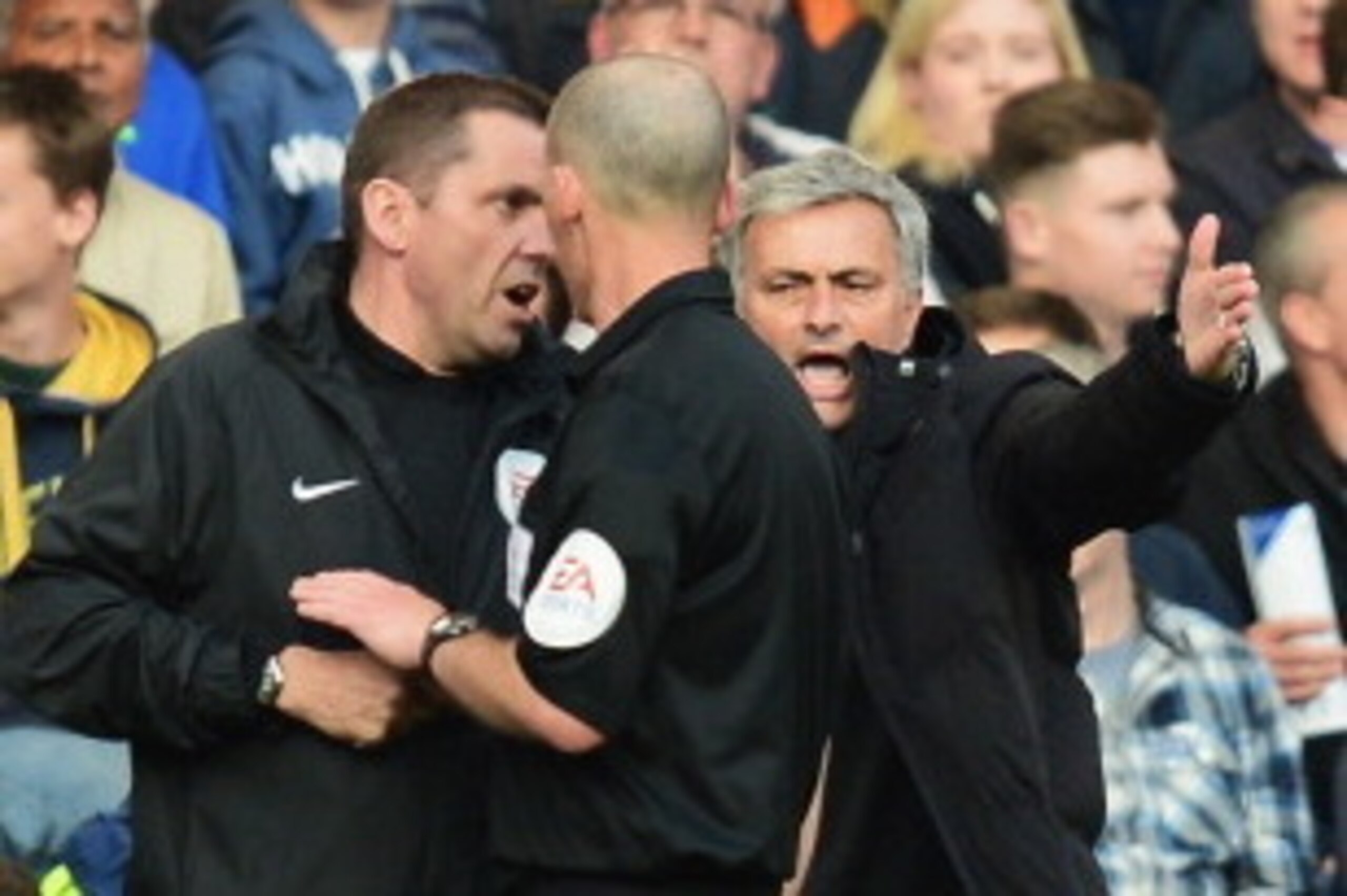 LONDON, ENGLAND - APRIL 19:  Chelsea manager Jose Mourinho talks to match referee Mike Dean and the fourth official during the Barclays Premier League match between Chelsea and Sunderland at Stamford Bridge on April 19, 2014 in London, England.  (Photo by