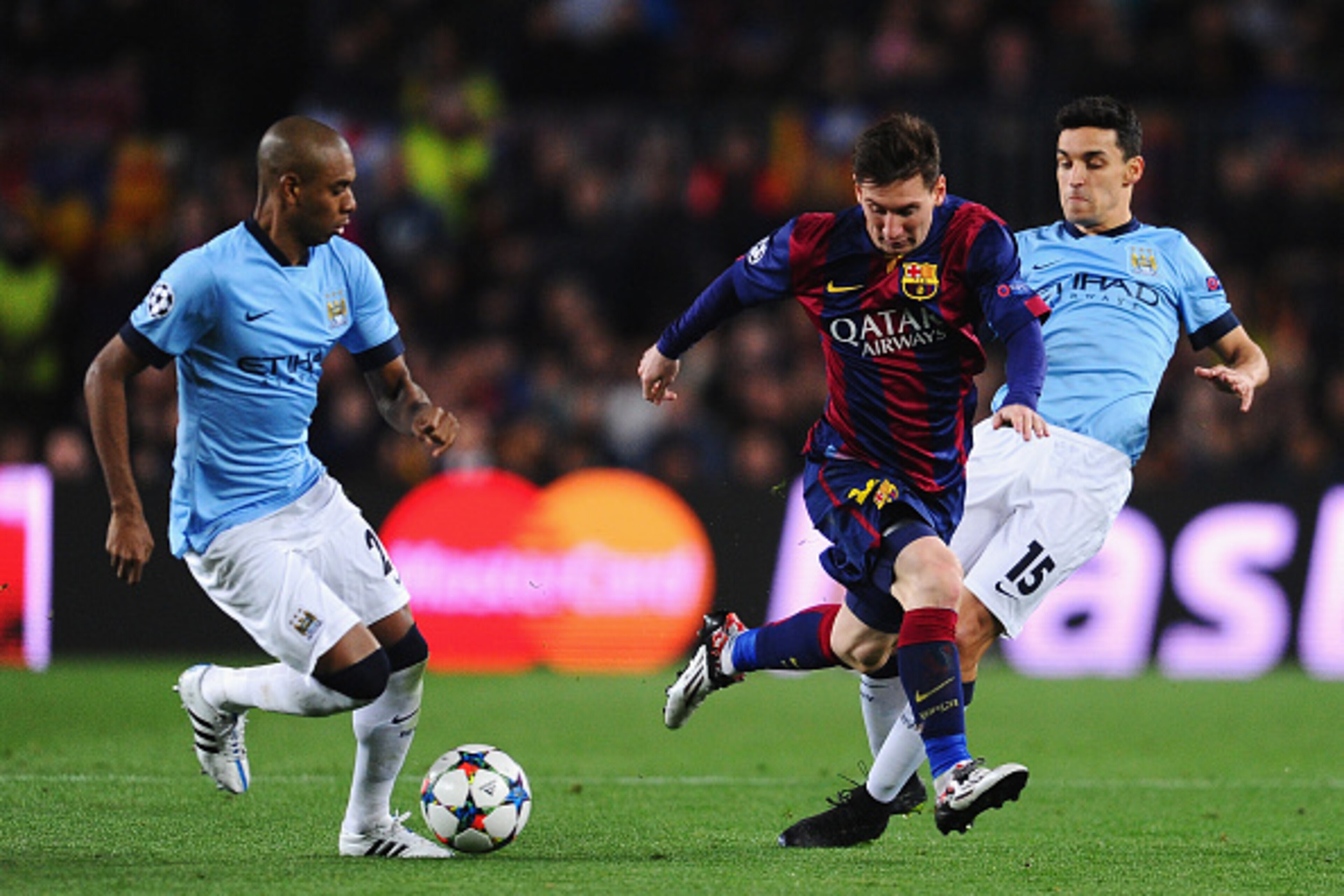 BARCELONA, SPAIN - MARCH 18:  Lionel Messi of Barcelona is challenged by Jesus Navas (R) of Manchester City during the UEFA Champions League Round of 16 second leg match between Barcelona and Manchester City at Camp Nou on March 18, 2015 in Barcelona, Spa