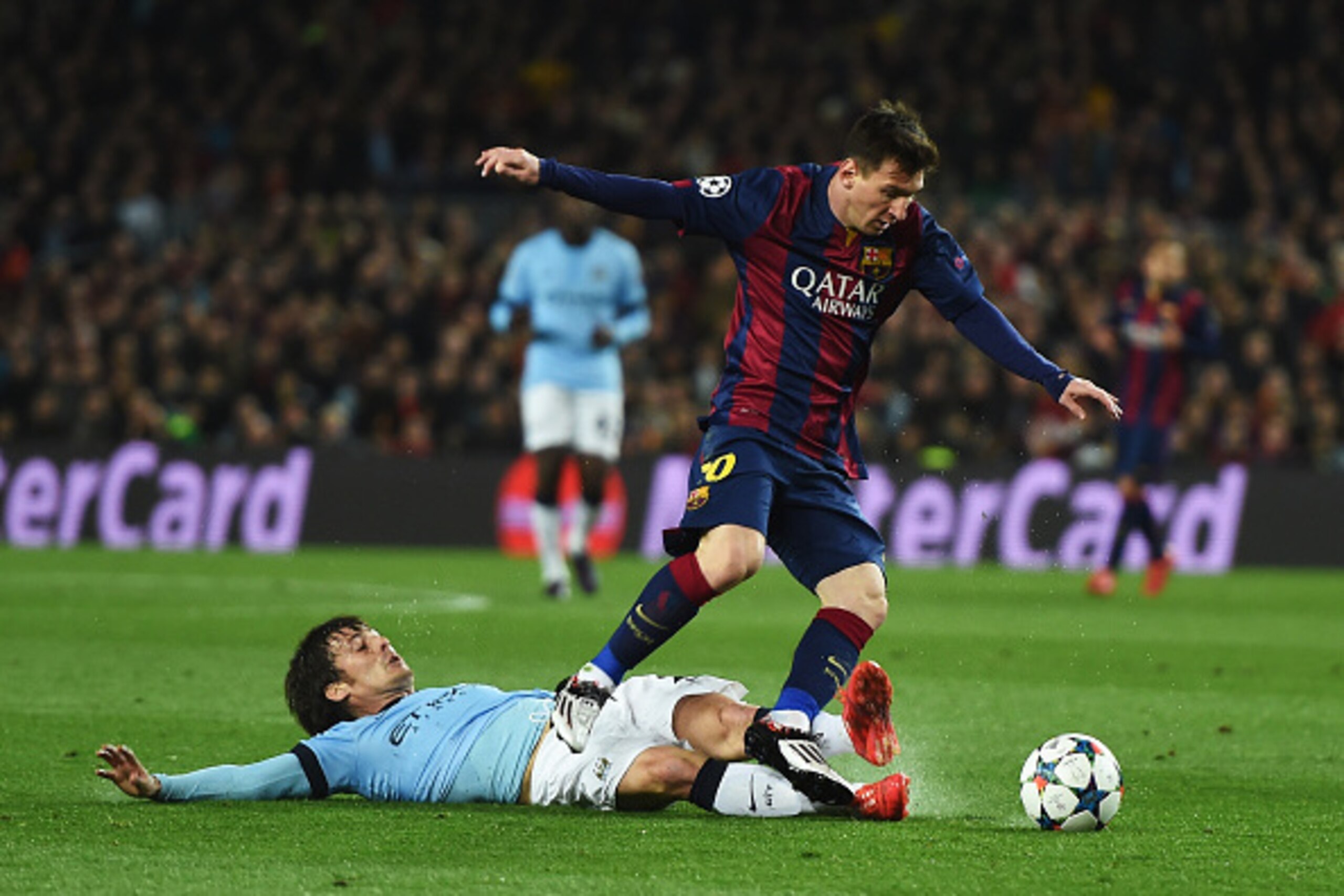 BARCELONA, SPAIN - MARCH 18:  David Silva of Manchester City tackles Lionel Messi of Barcelona during the UEFA Champions League Round of 16 second leg match between Barcelona and Manchester City at Camp Nou on March 18, 2015 in Barcelona, Spain.  (Photo b