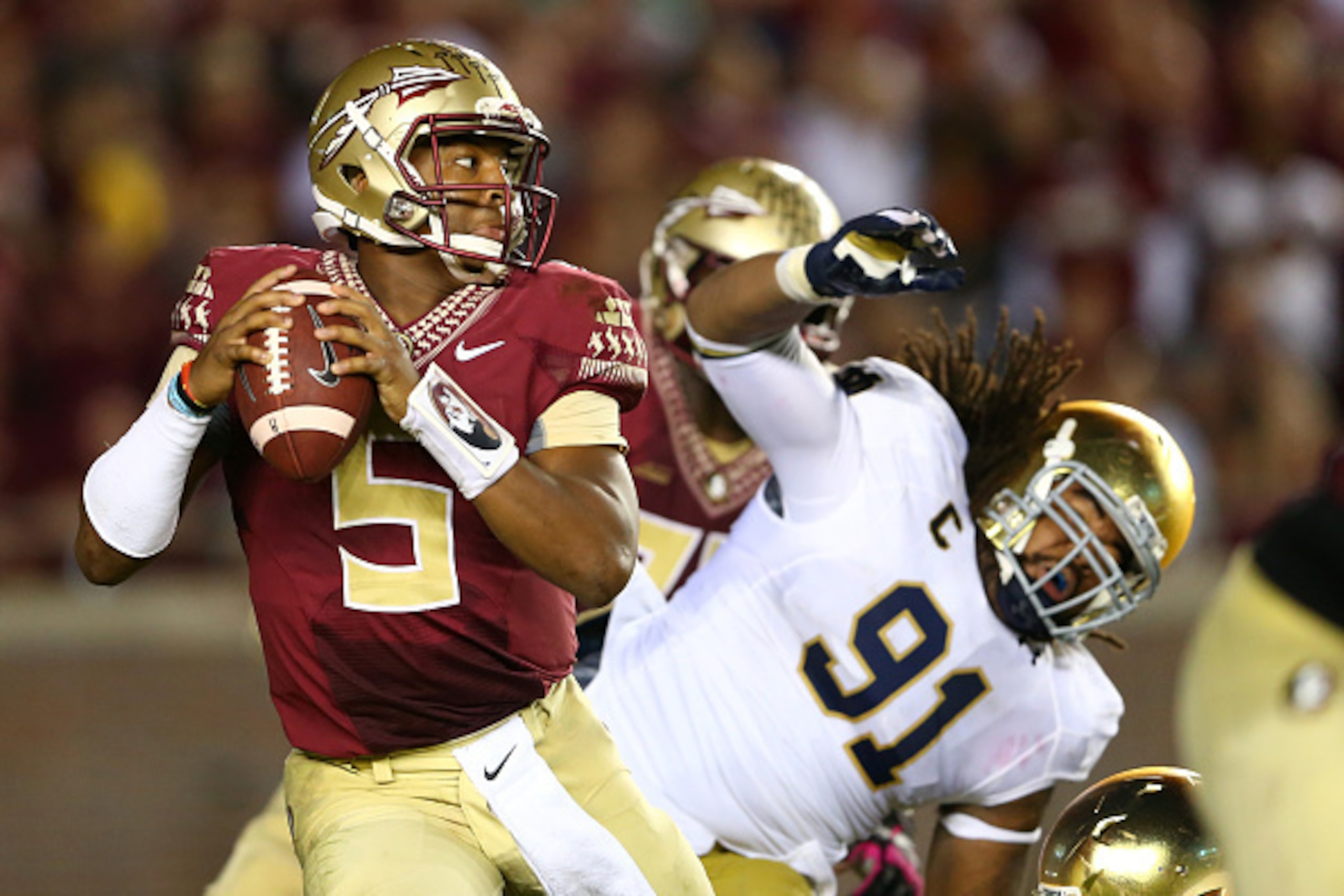 TALLAHASSEE, FL - OCTOBER 18:  Jameis Winston #5 of the Florida State Seminoles escapes from Sheldon Day #91 of the Notre Dame Fighting Irish during their game at Doak Campbell Stadium on October 18, 2014 in Tallahassee, Florida.  (Photo by Streeter Lecka