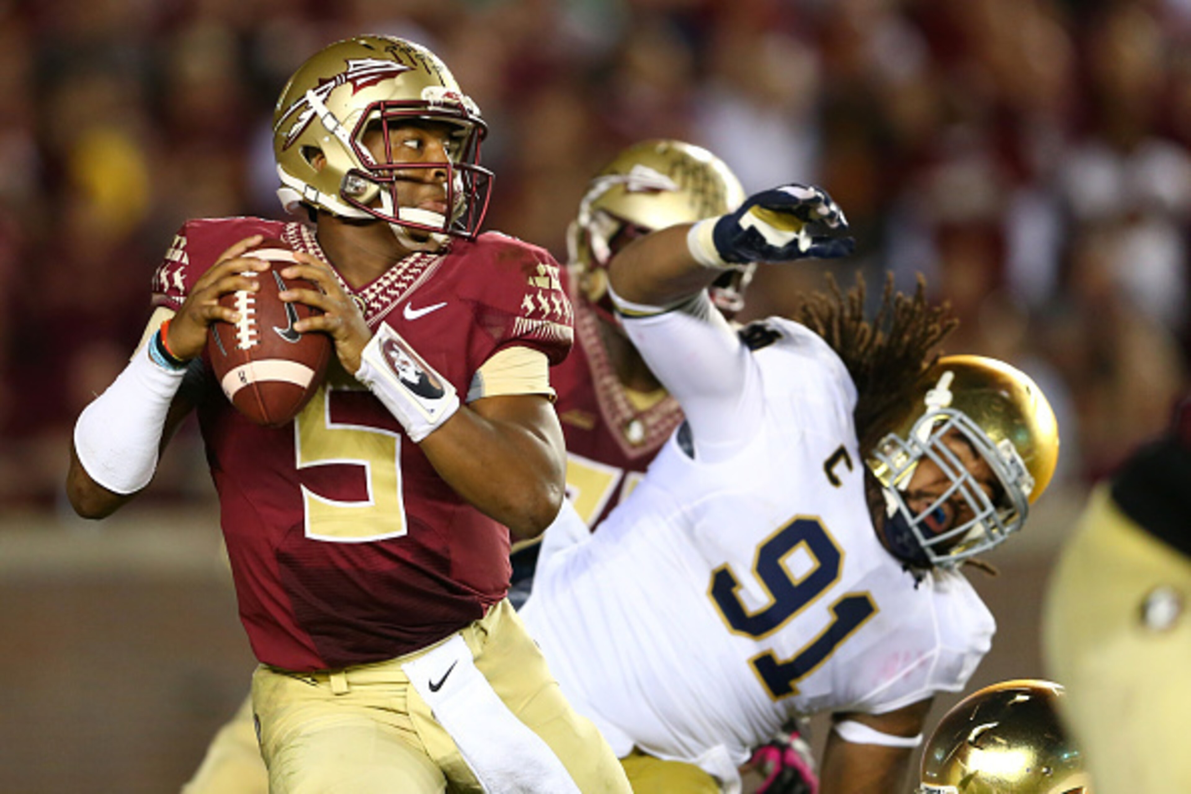 TALLAHASSEE, FL - OCTOBER 18:  Jameis Winston #5 of the Florida State Seminoles escapes from Sheldon Day #91 of the Notre Dame Fighting Irish during their game at Doak Campbell Stadium on October 18, 2014 in Tallahassee, Florida.  (Photo by Streeter Lecka
