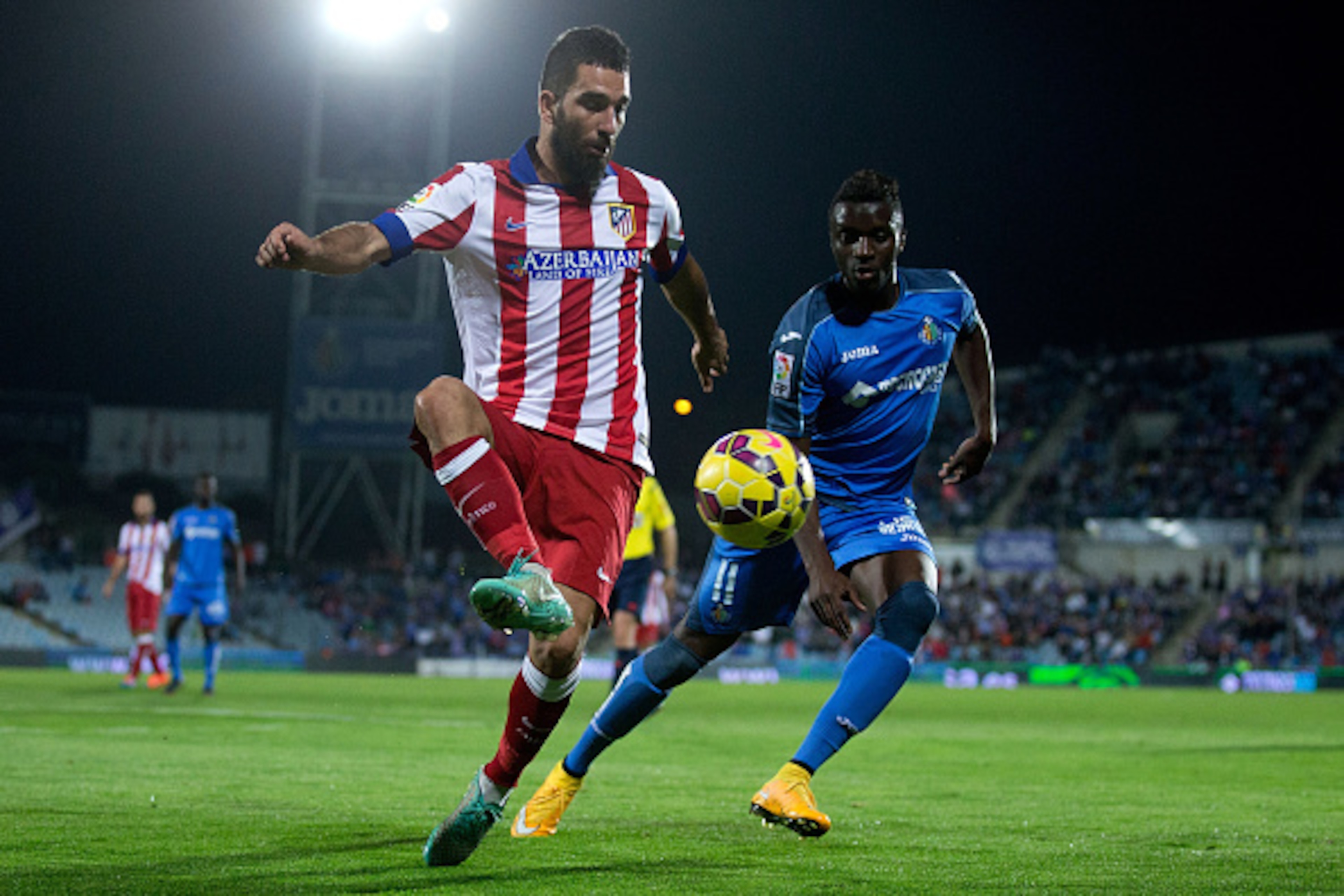 GETAFE, SPAIN - OCTOBER 26: Arda Turan (L) of Atletico de Madrid competes for the ball with Karim Abdoul Yoda (R) of Getafe CF during the La Liga match between Getafe CF and Club Atletico de Madrid at Coliseum Alfonso Perez on October 26, 2014 in Getafe, GETAFE, SPAIN - OCTOBER 26: Arda Turan (L) of Atletico de Madrid competes for the ball with Karim Abdoul Yoda (R) of Getafe CF during the La Liga match between Getafe CF and Club Atletico de Madrid at Coliseum Alfonso Perez on October 26, 2014 in Getafe,