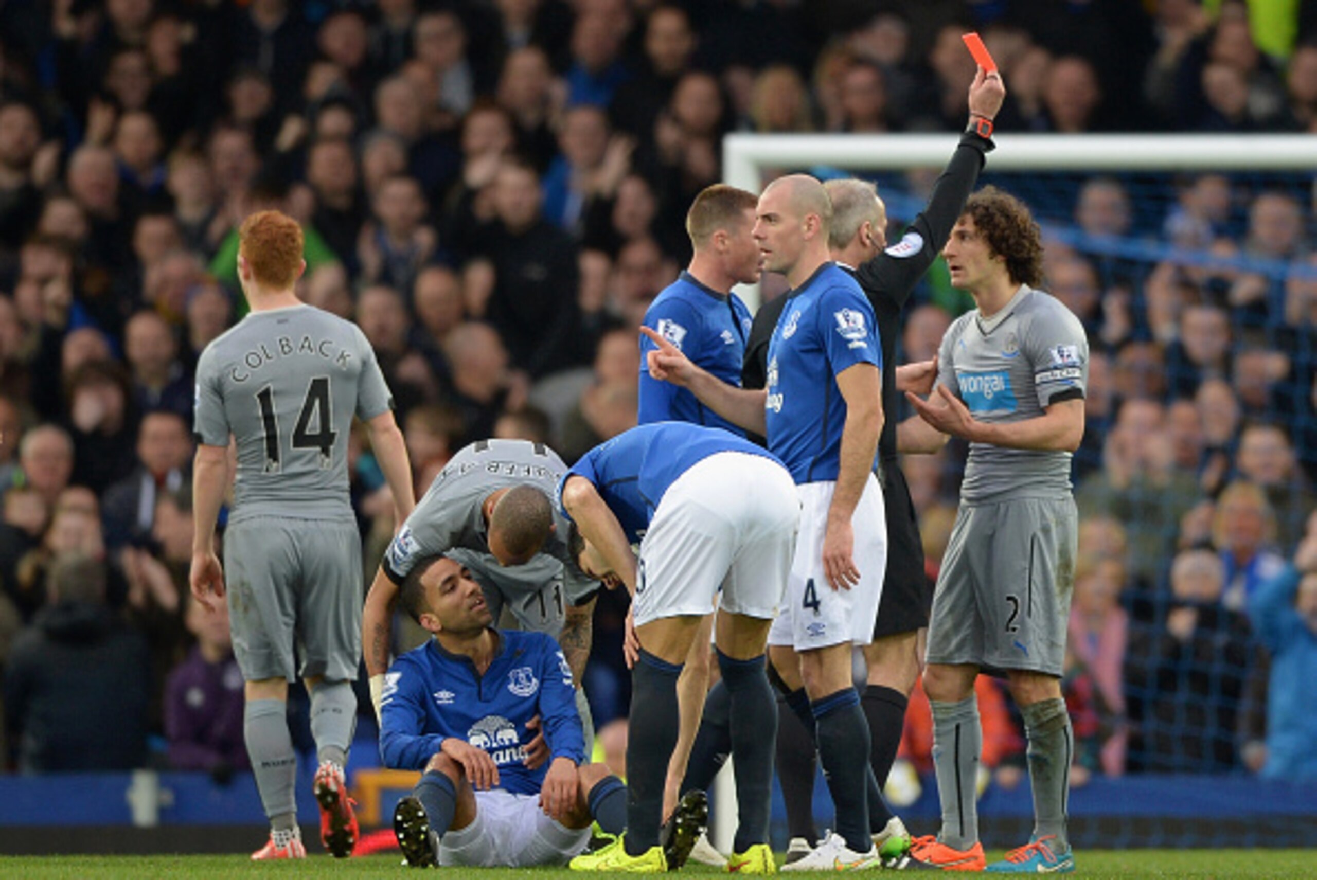 LIVERPOOL, ENGLAND - MARCH 15: Referee Martin Atkinson shows Fabricio Coloccini of Newcastle United a red card as Aaron Lennon of Everton sits on the pitch after the foul during the Barclays Premier League match between Everton and Newcastle United at Go LIVERPOOL, ENGLAND - MARCH 15: Referee Martin Atkinson shows Fabricio Coloccini of Newcastle United a red card as Aaron Lennon of Everton sits on the pitch after the foul during the Barclays Premier League match between Everton and Newcastle United at Go