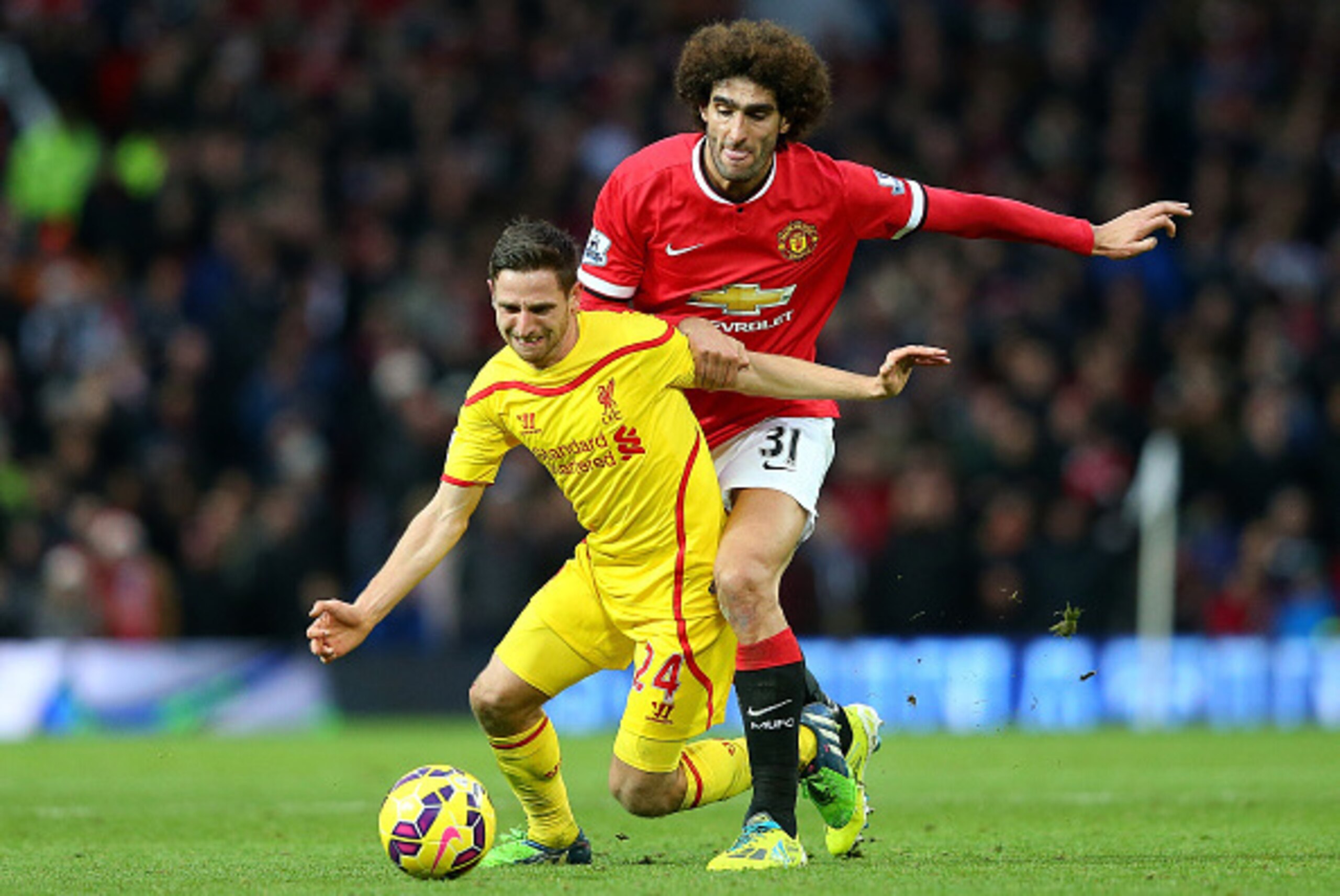 MANCHESTER, ENGLAND - DECEMBER 14:  Marouane Fellaini of Manchester United challenges Joe Allen of Liverpool during the Barclays Premier League match between Manchester United and Liverpool at Old Trafford on December 14, 2014 in Manchester, England.  (Ph