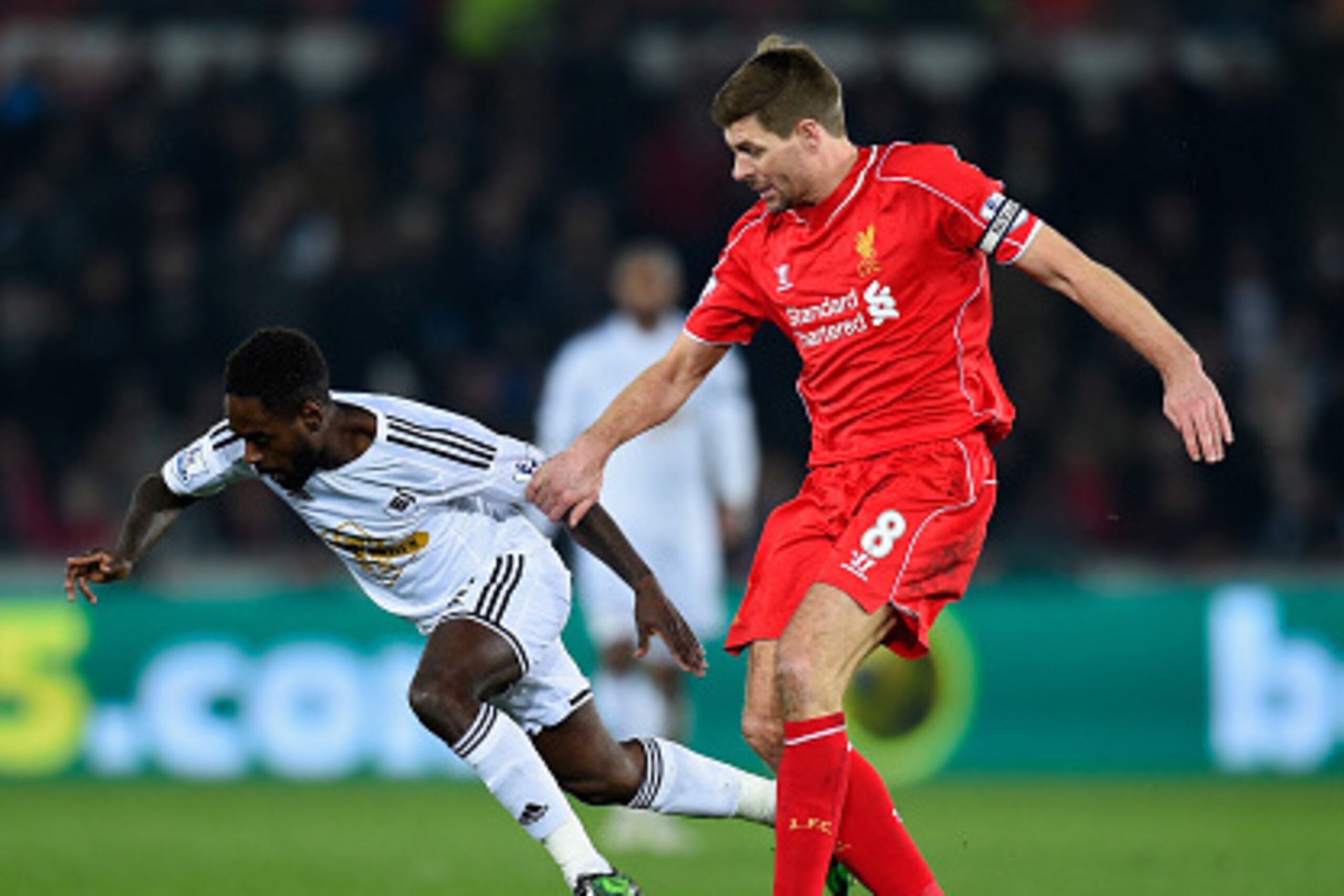 SWANSEA, WALES - MARCH 16:  Liverpool player Steven Gerrard (r) challenges Nathan Dyer of Swansea during the Barclays Premiership match between Swansea City and Liverpool at Liberty Stadium on March 16, 2015 in Swansea, Wales.  (Photo by Stu Forster/Getty