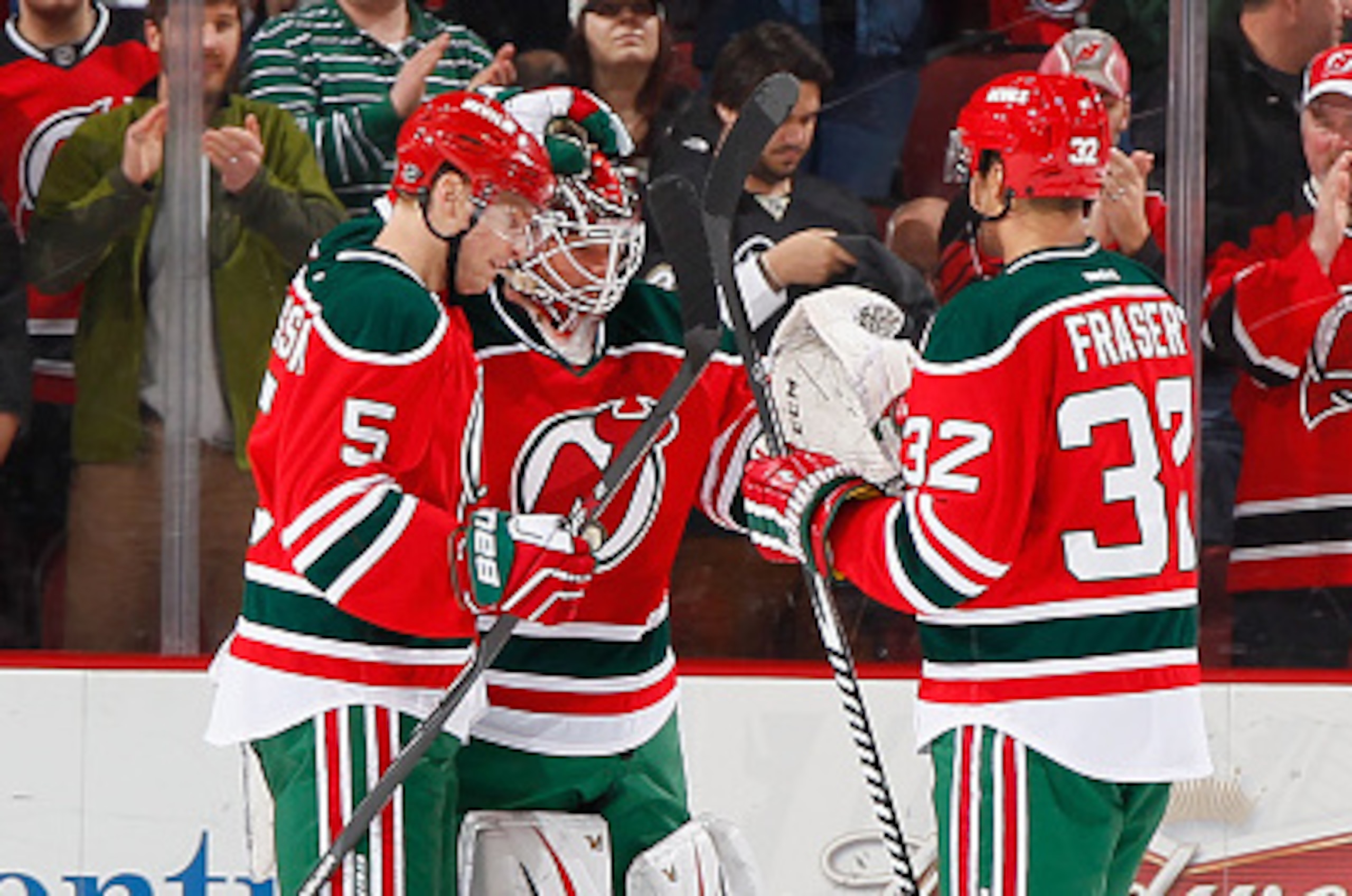 NEWARK, NJ - MARCH 17: Winning goaltender Cory Schneider #35 of the New Jersey Devils is congratulated by Adam Larsson #5 and Mark Fraser #32 after the Devils defeated the Pittsburgh Penguins at the Prudential Center on March 17, 2015 in Newark, New Jerse