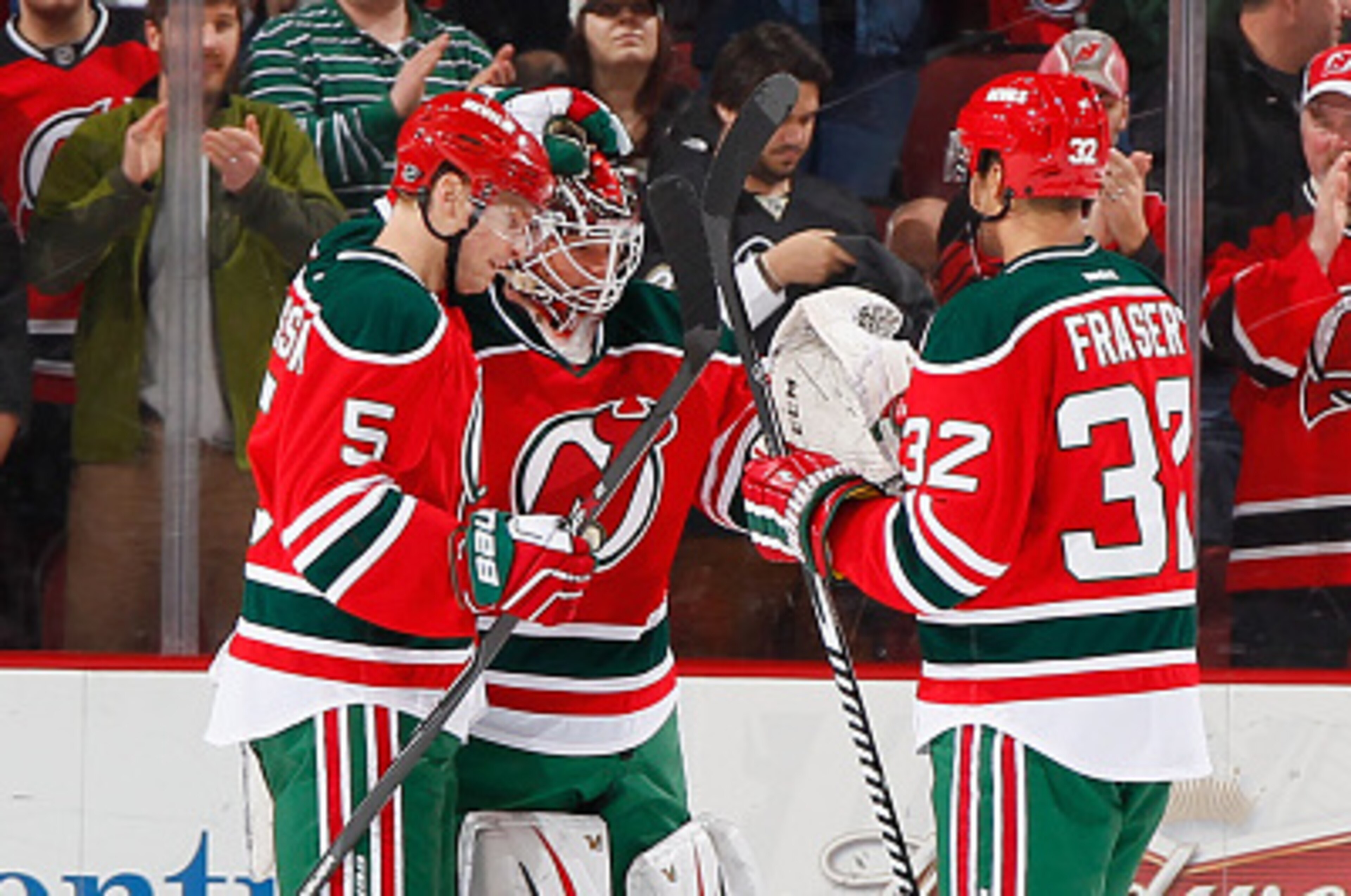 NEWARK, NJ - MARCH 17: Winning goaltender Cory Schneider #35 of the New Jersey Devils is congratulated by Adam Larsson #5 and Mark Fraser #32 after the Devils defeated the Pittsburgh Penguins at the Prudential Center on March 17, 2015 in Newark, New Jerse