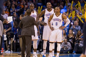 OKLAHOMA CITY, OK - JANUARY 2: Head Coach Scott Brooks, Serge Ibaka #9, Kevin Durant #35, and Russell Westbrook #0 of the Oklahoma City Thunder speak during a game against the Washington Wizards at the Chesapeake Energy Arena  on January 2, 2015 in Oklaho