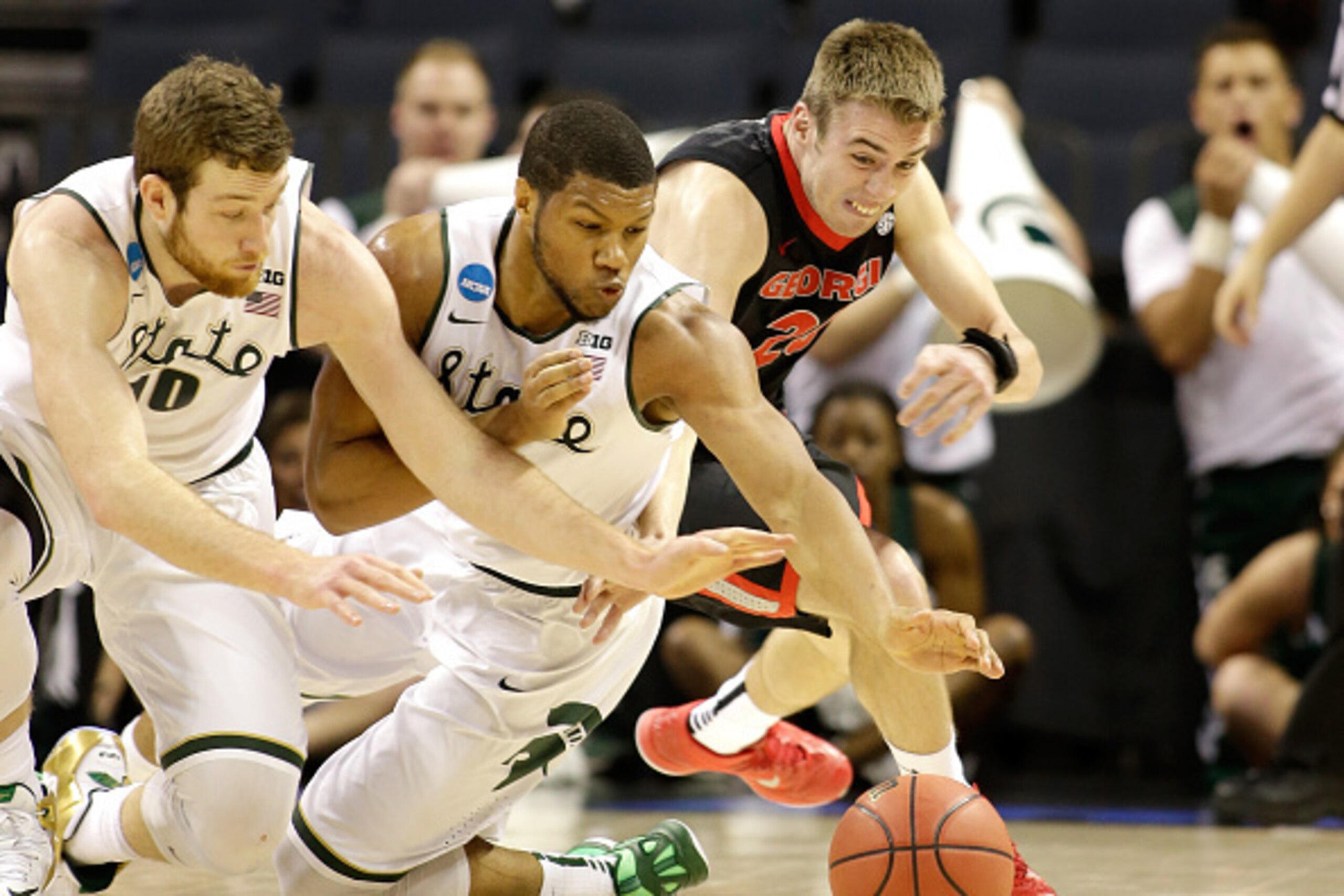 CHARLOTTE, NC - MARCH 20:  Kenny Paul Geno #25 of the Georgia Bulldogs goes after a loose ball against teammates Matt Costello #10 and Marvin Clark Jr. #0 of the Michigan State Spartans during the second round of the 2015 NCAA Men's Basketball Tournament 