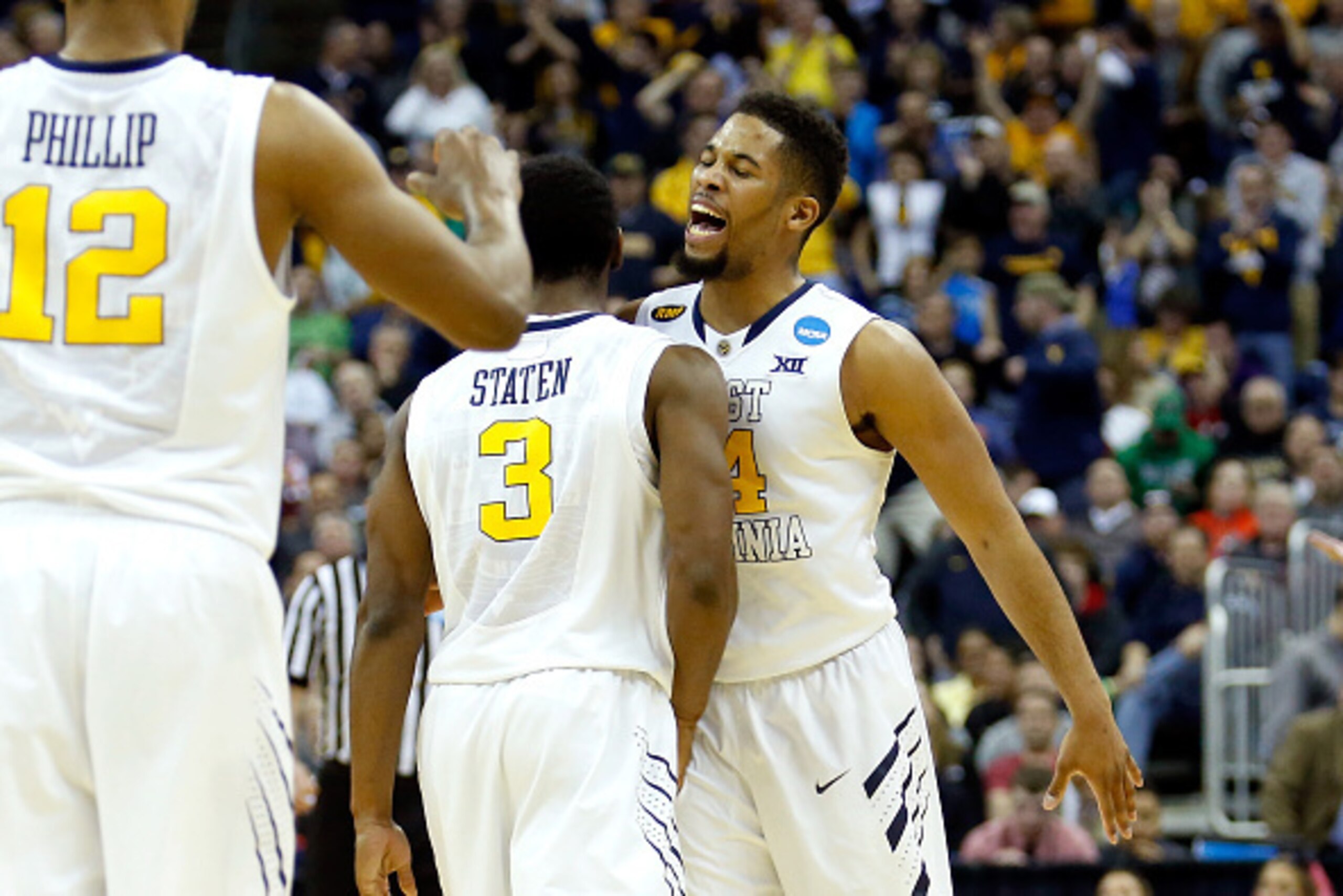 COLUMBUS, OH - MARCH 20: Juwan Staten #3 and Gary Browne #14 of the West Virginia Mountaineers celebrate after defeating the Buffalo Bulls during the second round of the 2015 NCAA Men's Basketball Tournament at Nationwide Arena on March 20, 2015 in Columb