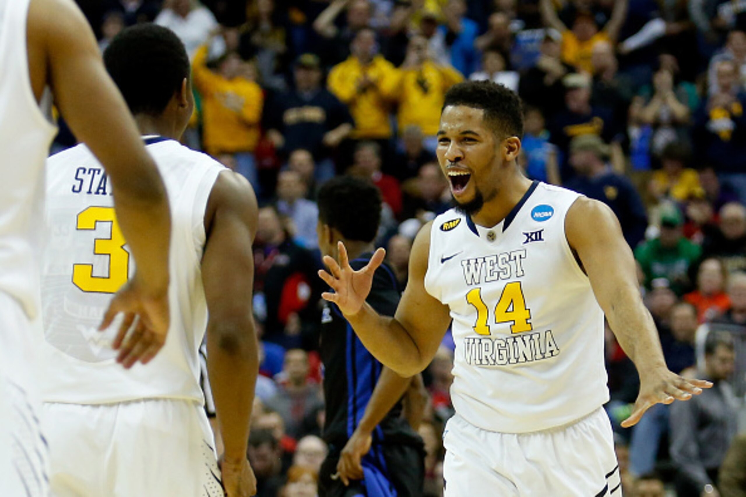COLUMBUS, OH - MARCH 20:  Juwan Staten #3 and Gary Browne #14 of the West Virginia Mountaineers celebrate after defeating the Buffalo Bulls during the second round of the 2015 NCAA Men's Basketball Tournament at Nationwide Arena on March 20, 2015 in Colum