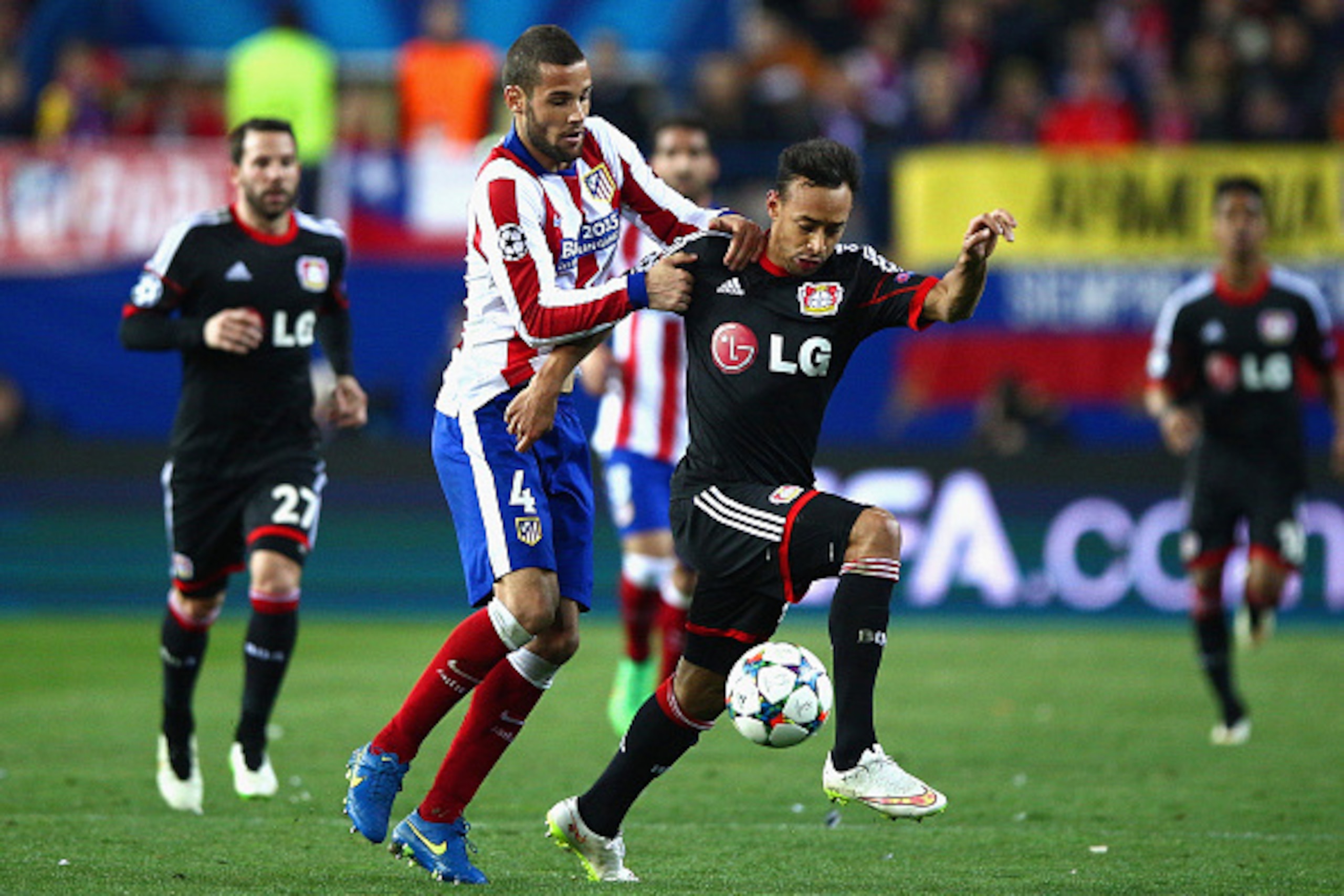 MADRID, SPAIN - MARCH 17: Mario Suarez of Atletico Madrid challenges Karim Bellarabi of Bayer Leverkusen uring the UEFA Champions League round of 16 match between Club Atletico de Madrid and Bayer 04 Leverkusen at Vicente Calderon Stadium on March 17, 201