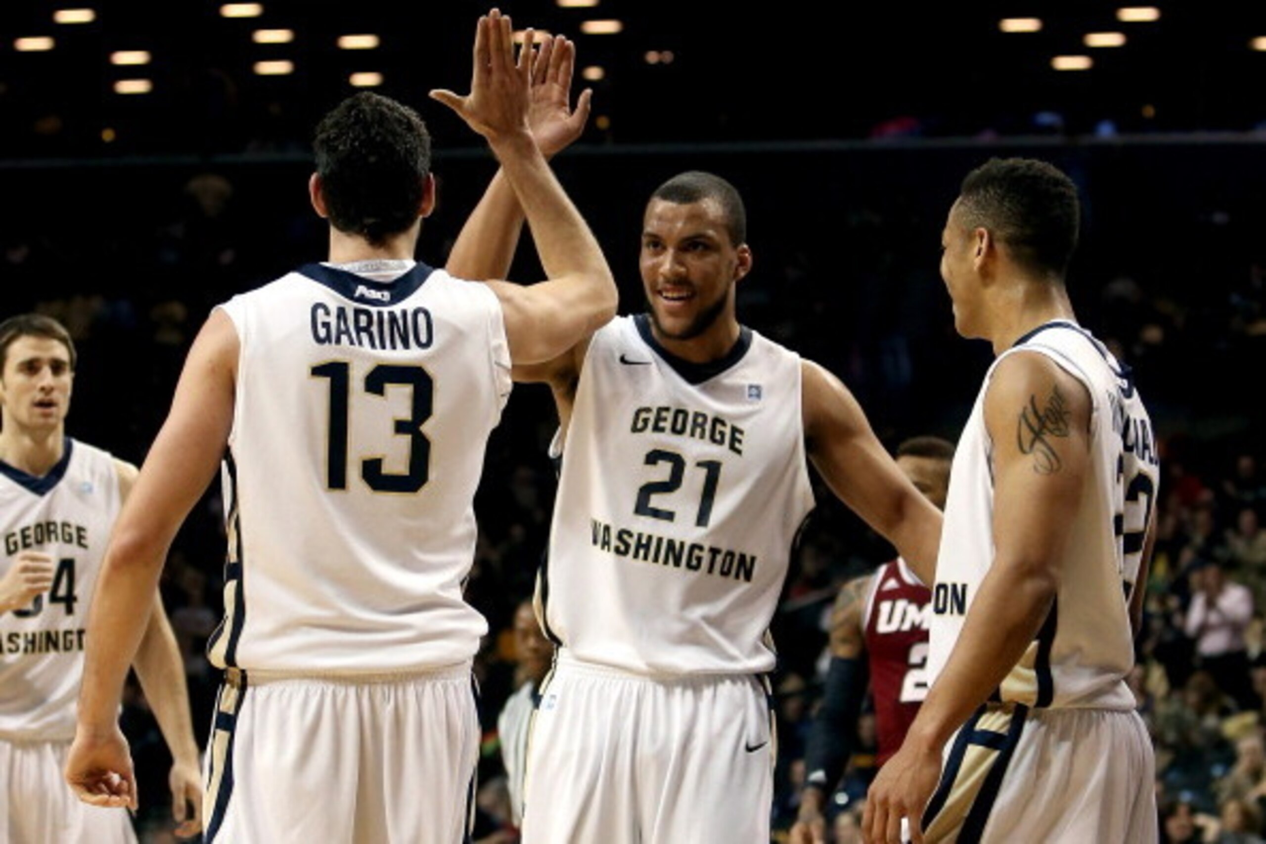 NEW YORK, NY - MARCH 14: Patricio Garino #13 of the George Washington Colonials celebrates with Kevin Larsen #21 and Joe McDonald #22 after a play in the first half against the Massachusetts Minutemen during the Quarterfinals of the 2014 Atlantic 10 Men's
