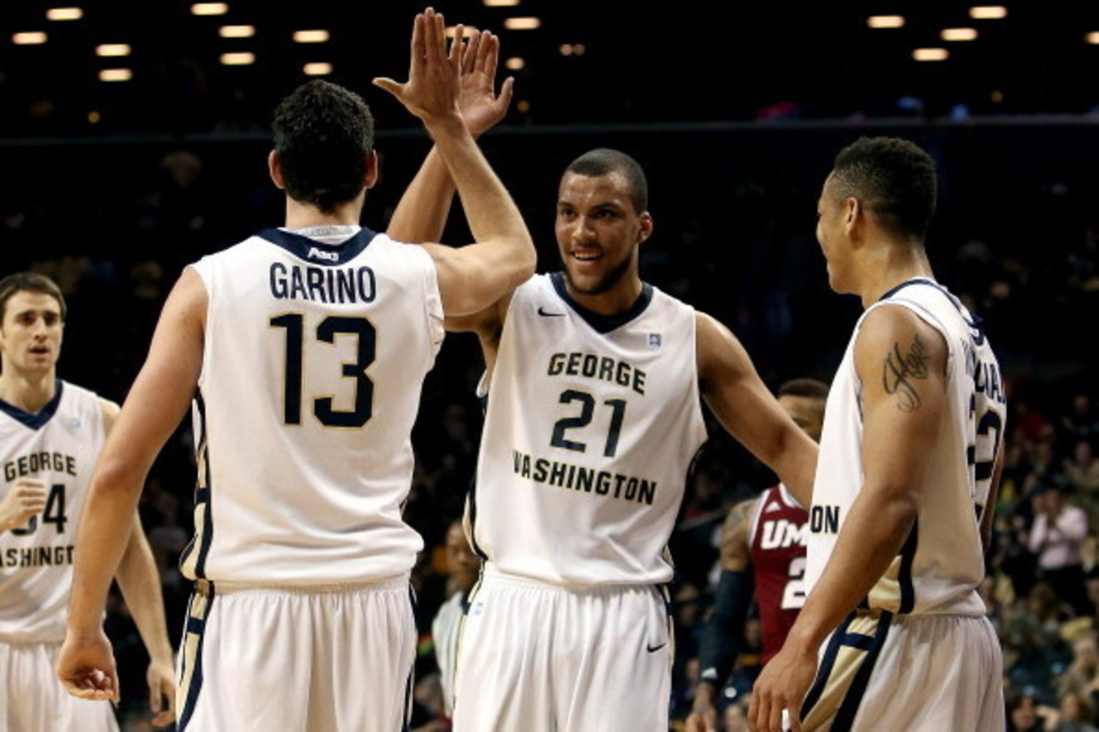 NEW YORK, NY - MARCH 14: Patricio Garino #13 of the George Washington Colonials celebrates with Kevin Larsen #21 and Joe McDonald #22 after a play in the first half against the Massachusetts Minutemen during the Quarterfinals of the 2014 Atlantic 10 Men's