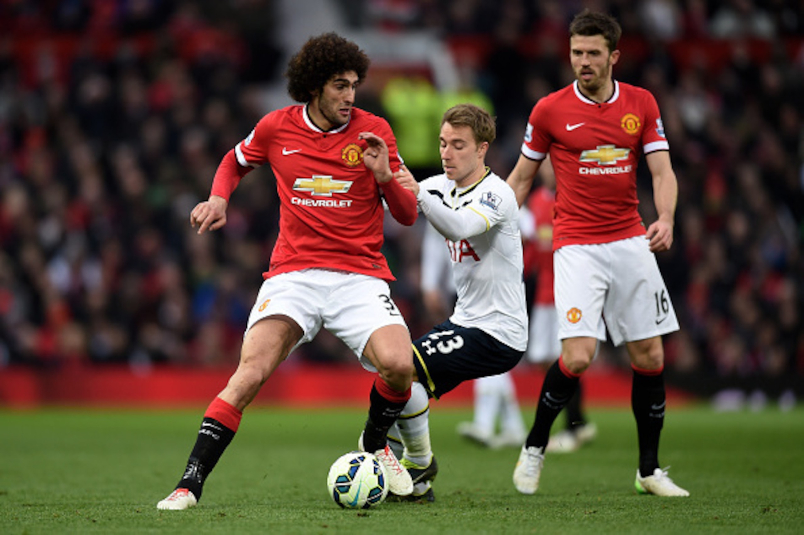 MANCHESTER, ENGLAND - MARCH 15:  Marouane Fellaini of Manchester United is challenged by Christian Eriksen of Spurs during the Barclays Premier League match between Manchester United and Tottenham Hotspur at Old Trafford on March 15, 2015 in Manchester, E