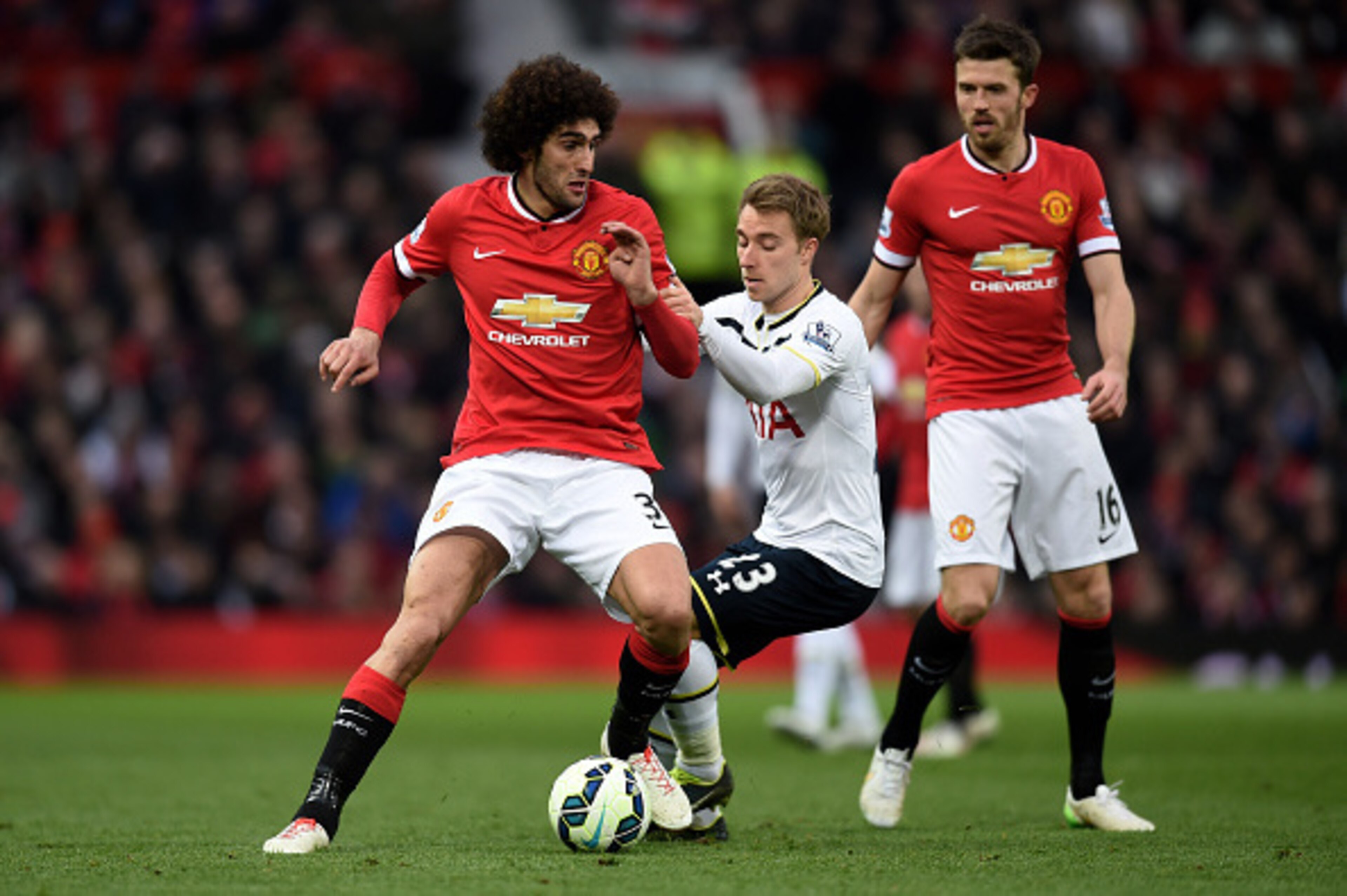 MANCHESTER, ENGLAND - MARCH 15:  Marouane Fellaini of Manchester United is challenged by Christian Eriksen of Spurs during the Barclays Premier League match between Manchester United and Tottenham Hotspur at Old Trafford on March 15, 2015 in Manchester, E