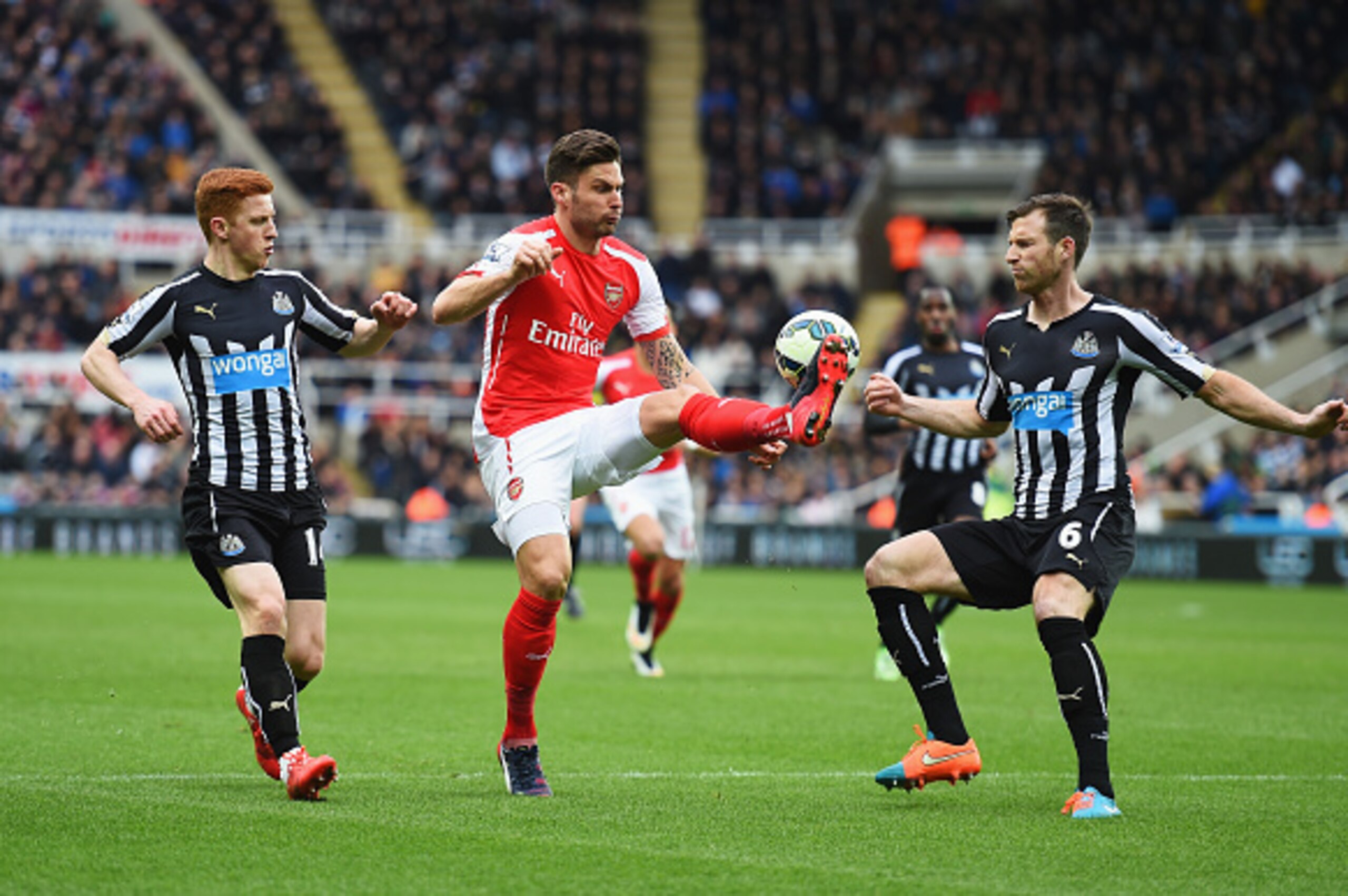 NEWCASTLE UPON TYNE, ENGLAND - MARCH 21:  Olivier Giroud of Arsenal is closed down by Mike Williamson (R) and Jack Colback of Newcastle United during the Barclays Premier League match between Newcastle United and Arsenal at St James' Park on March 21, 201