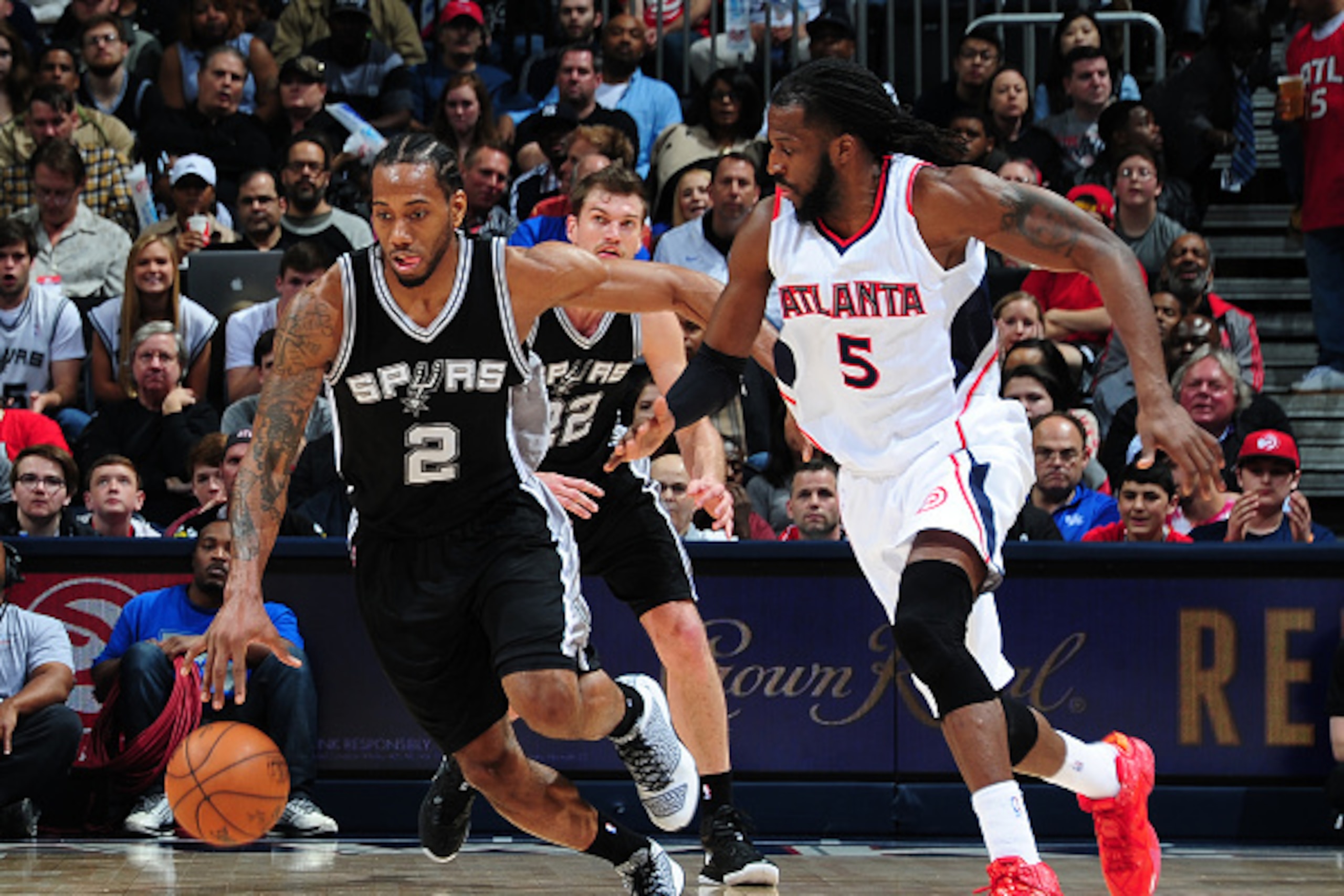 ATLANTA, GA - MARCH 22:  Kawhi Leonard #2 of the San Antonio Spurs handles the ball against DeMarre Carroll #5 of the Atlanta Hawks on March 22, 2015 at Philips Arena in Atlanta, Georgia.  NOTE TO USER: User expressly acknowledges and agrees that, by down